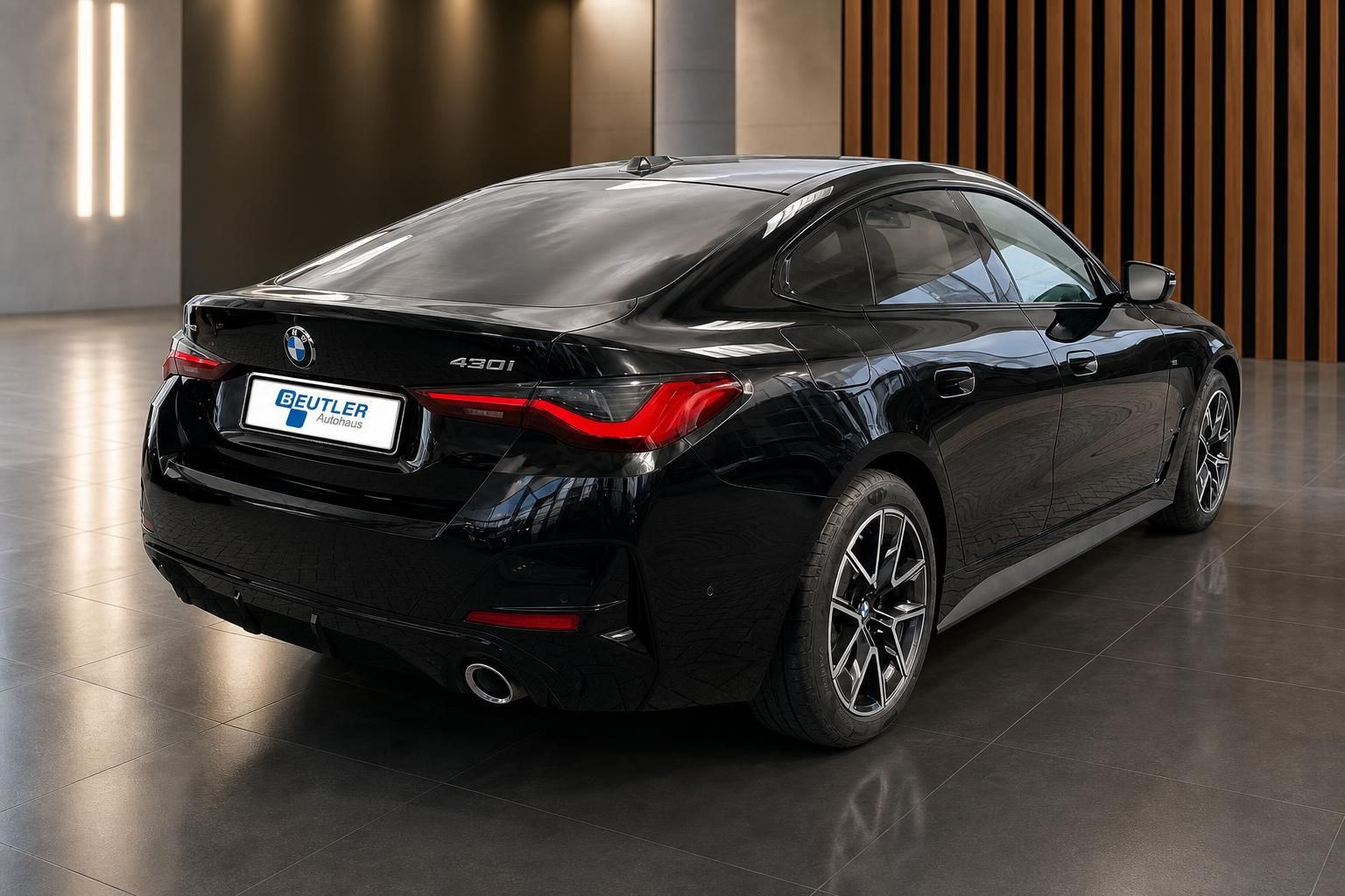 BMW 430i schwarz, Heck-Seitenansicht im modernen Showroom