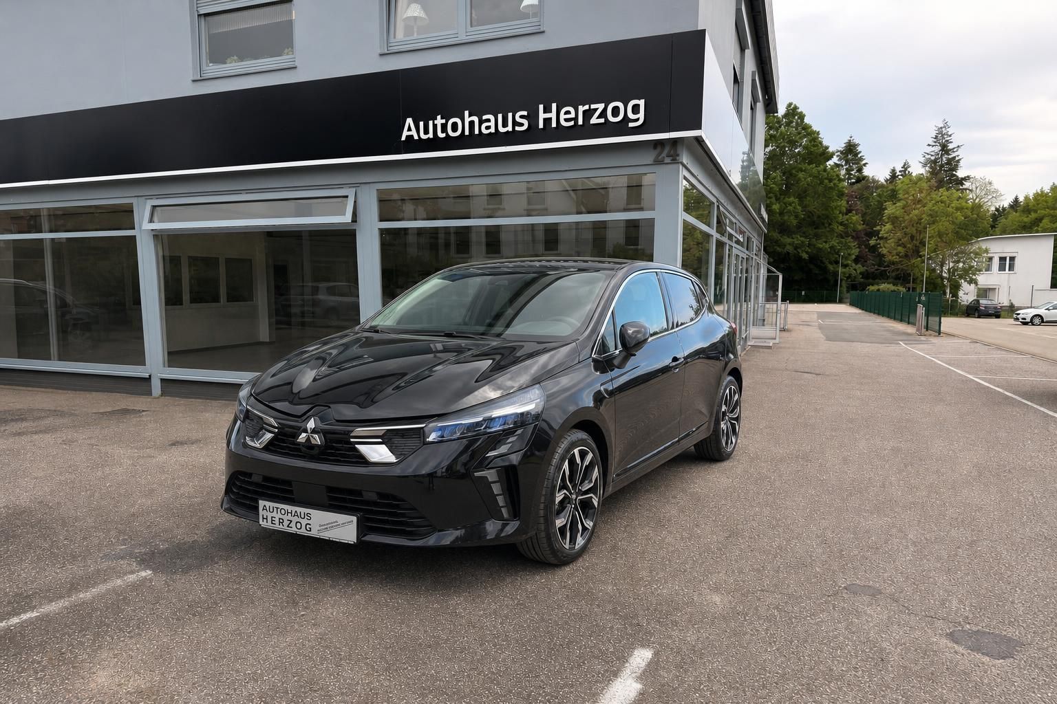Schwarzer Renault Kleinwagen vor Autohaus Herzog - Frontansicht mit modernem Design und LED-Scheinwerfern