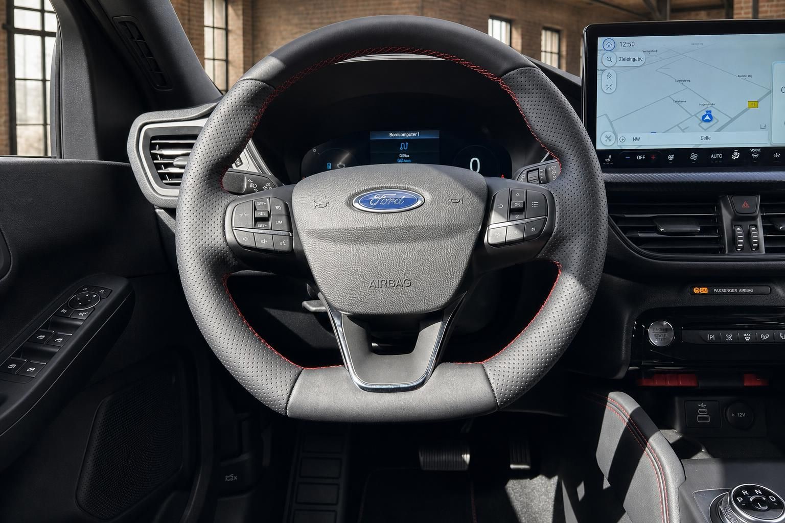Ford Focus Sportlenkrad Nahaufnahme mit Ford-Logo, roten Ziernähten und Navigationsdisplay