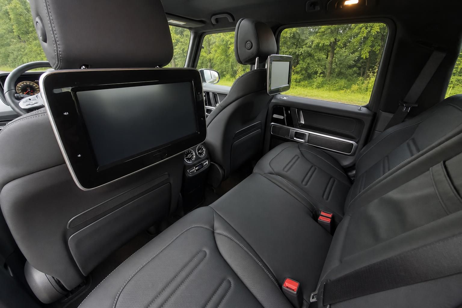 Luxuriöser Fahrzeuginnenraum mit schwarzen Ledersitzen und Entertainment-System für die Rücksitzpassagiere