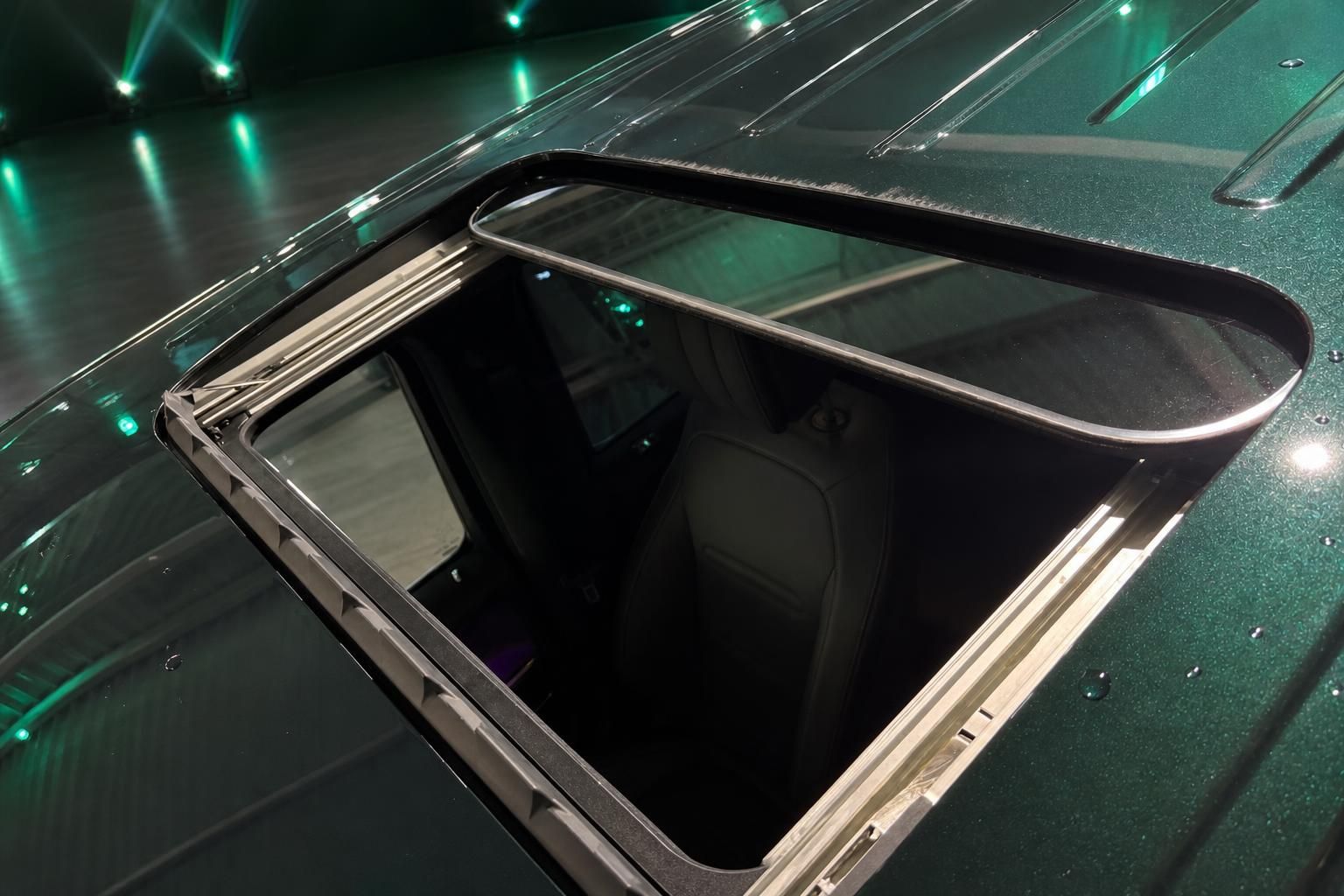 Fahrzeug-Panoramadach in grünem Metallicfinish mit geöffnetem Schiebedach und Detailansicht der Dachlinien