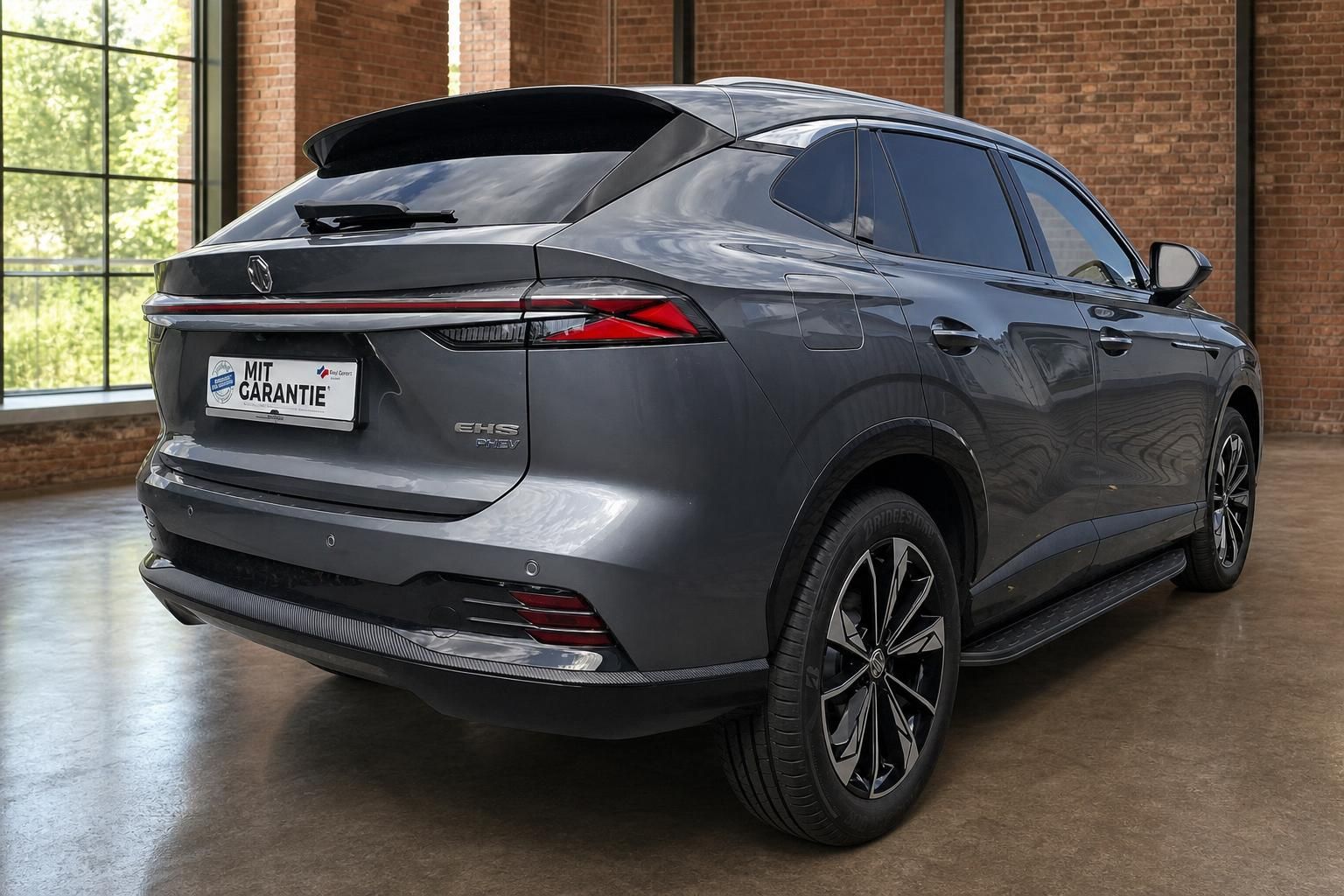 MG EHS PHEV Grau, Heckansicht schraeg im Showroom
