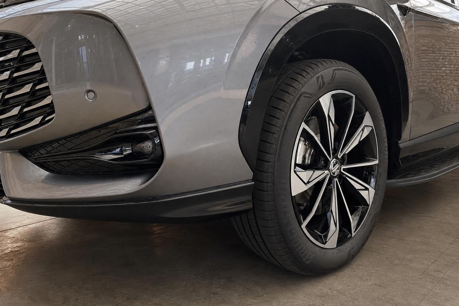 Detailansicht Vorderrad und Stossfaenger eines grauen MG SUV
