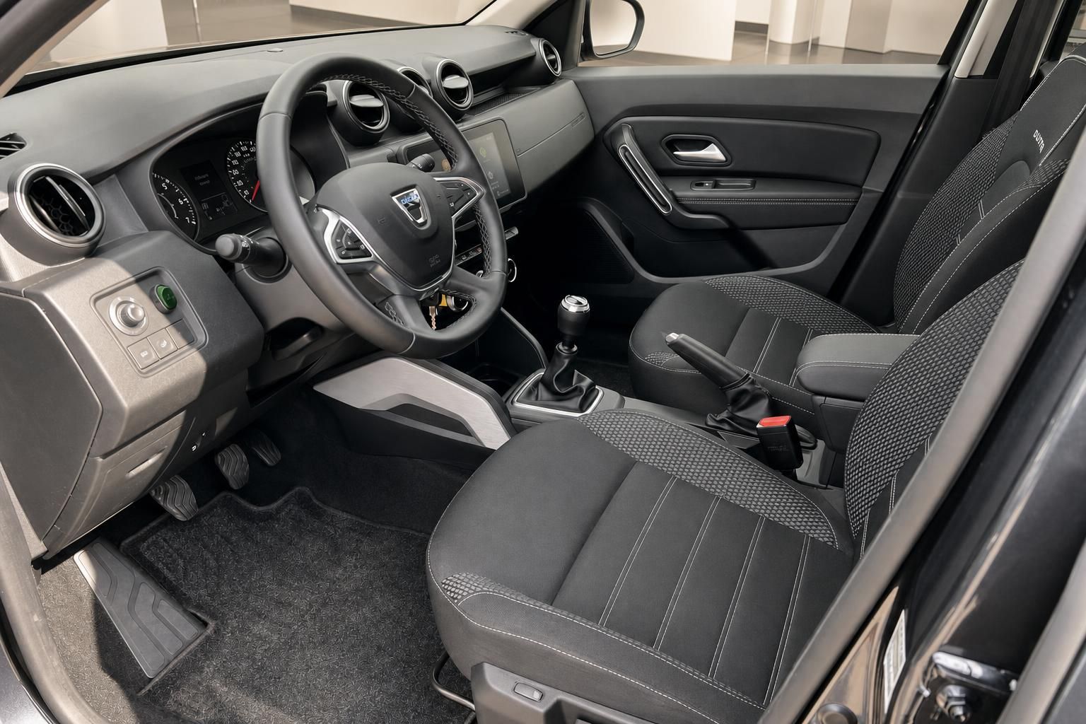 Dacia Fahrerplatz mit Lenkrad, Instrumententafel und grau-schwarzer Sitzausstattung