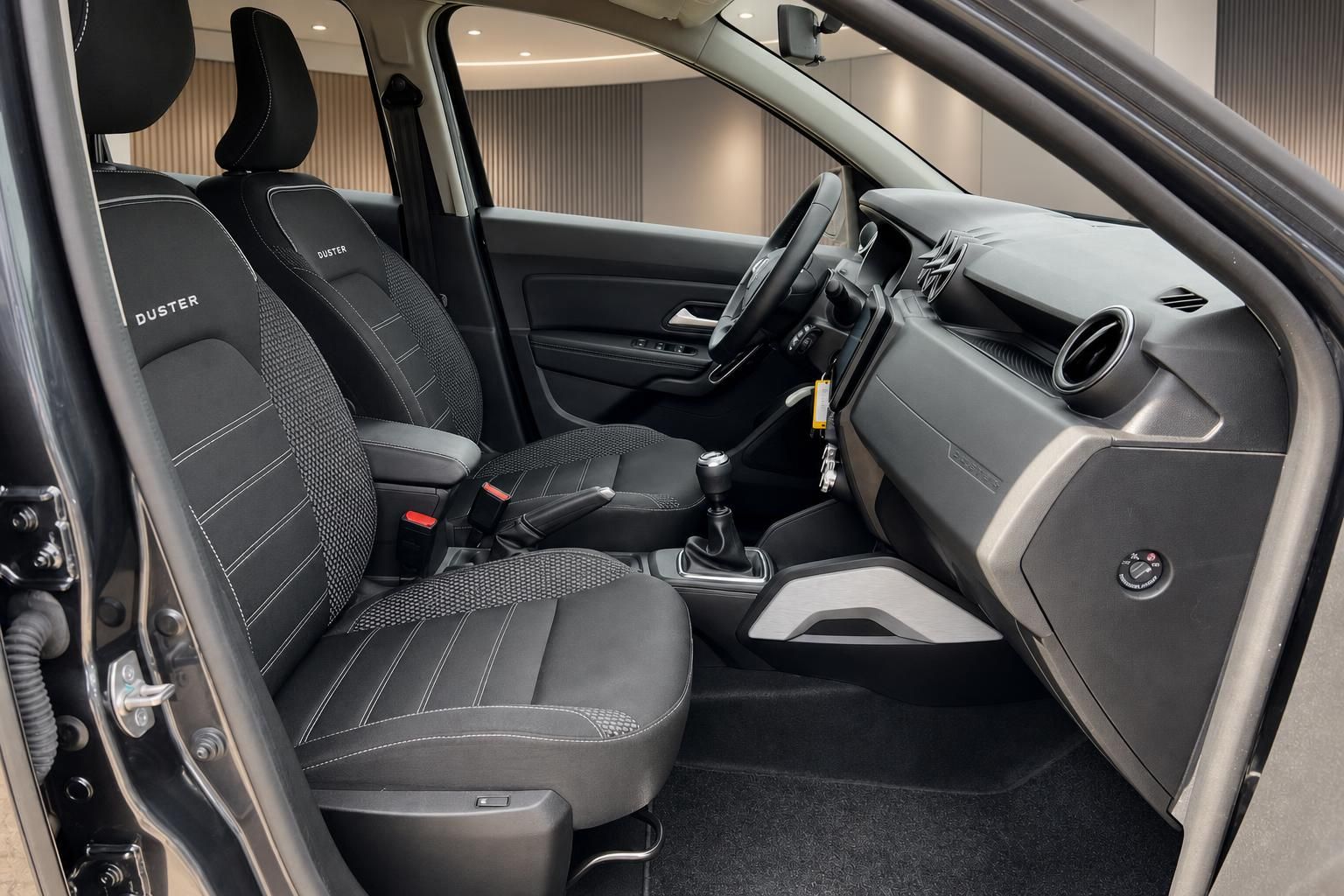 Dacia Duster Innenraum mit schwarzen Sportsitzen und manueller Schaltung
