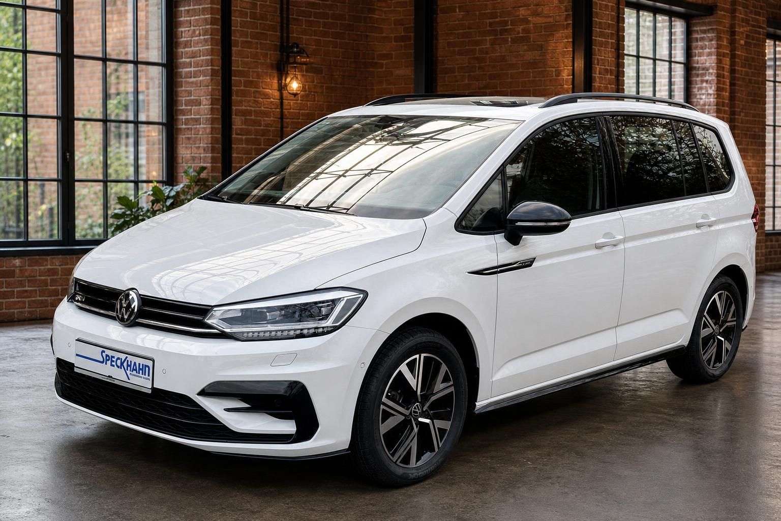 VW Touran R-Line weiss Frontansicht schraeg in Loft-Ausstellungsraum