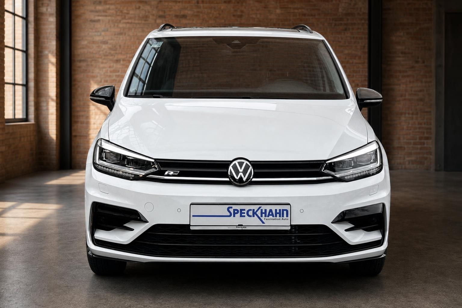VW Touran R-Line weiß Frontansicht in moderner Halle