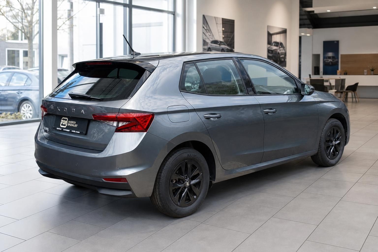 Škoda Scala grau, Heckansicht schräg im Autohaus Showroom
