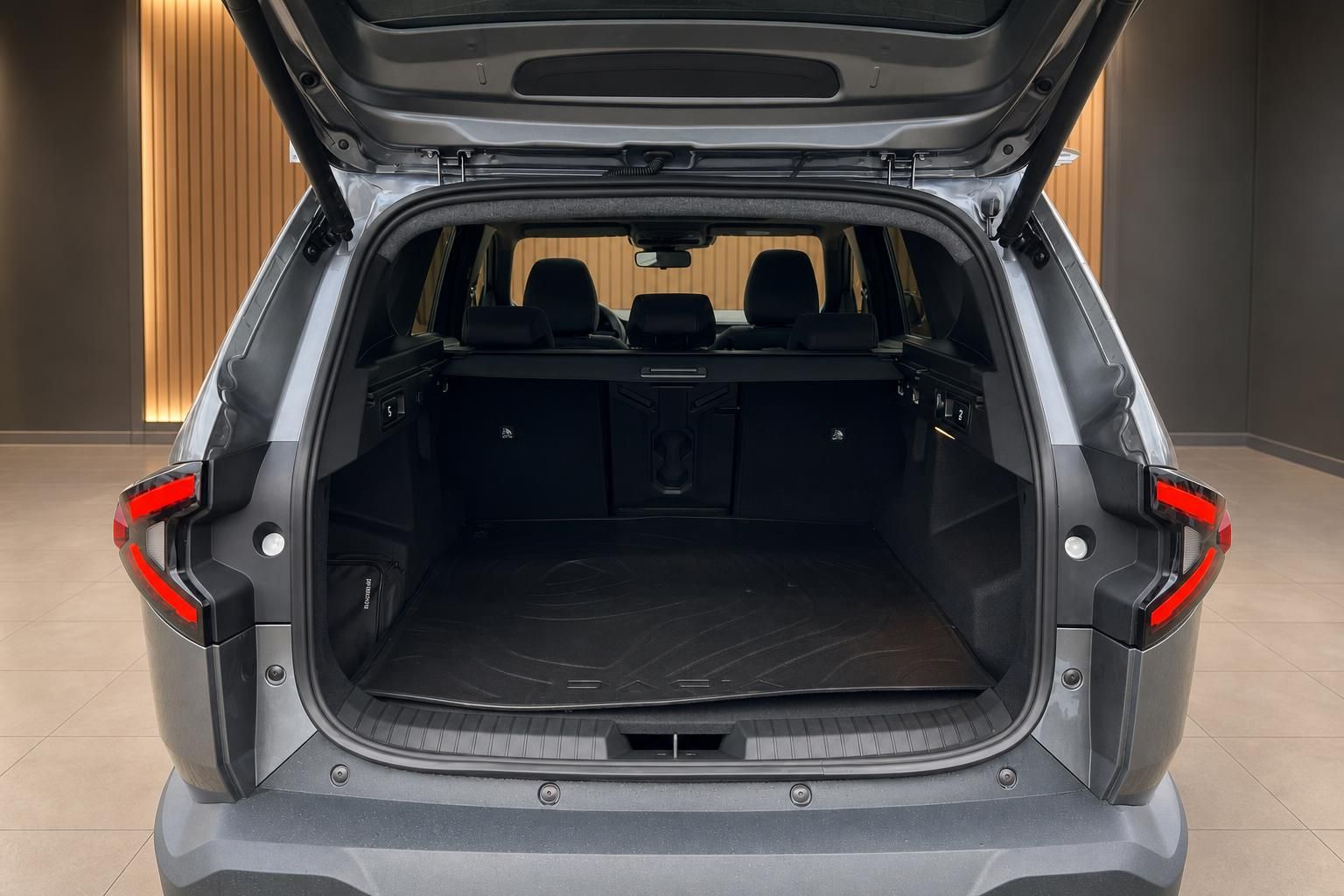 Offener Kofferraum eines grauen SUV mit schwarzer Innenausstattung und geöffneter Heckklappe