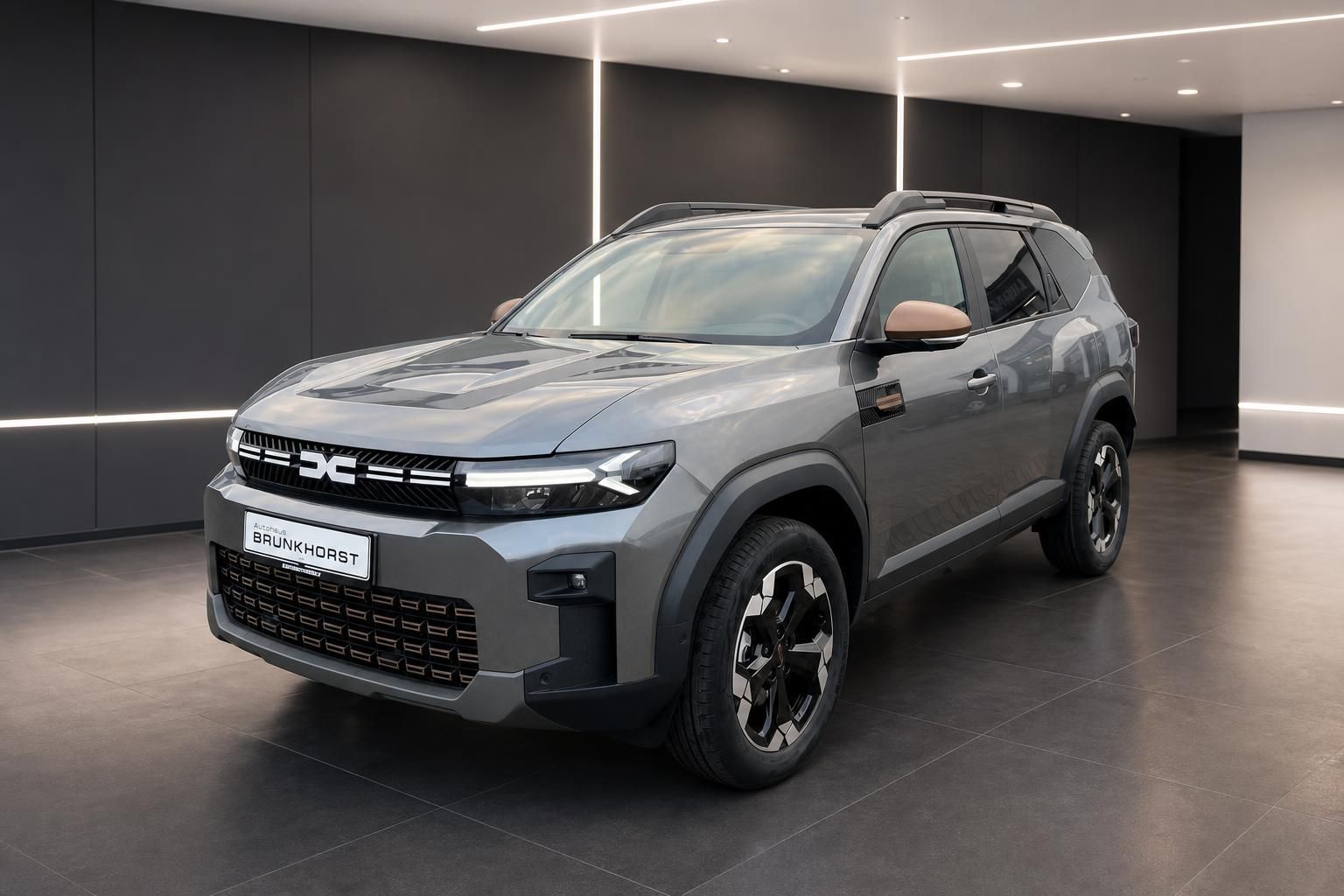 Dacia Bigster SUV in grau - Frontansicht im modernen Autohaus Showroom