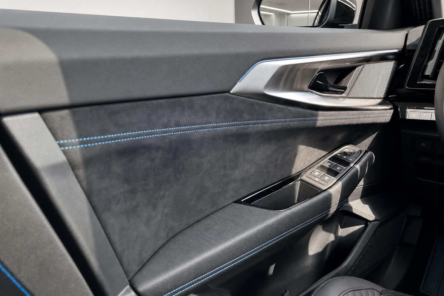 Innenraumdetail Türverkleidung mit Fensterheberschalter und blauer Ziernaht