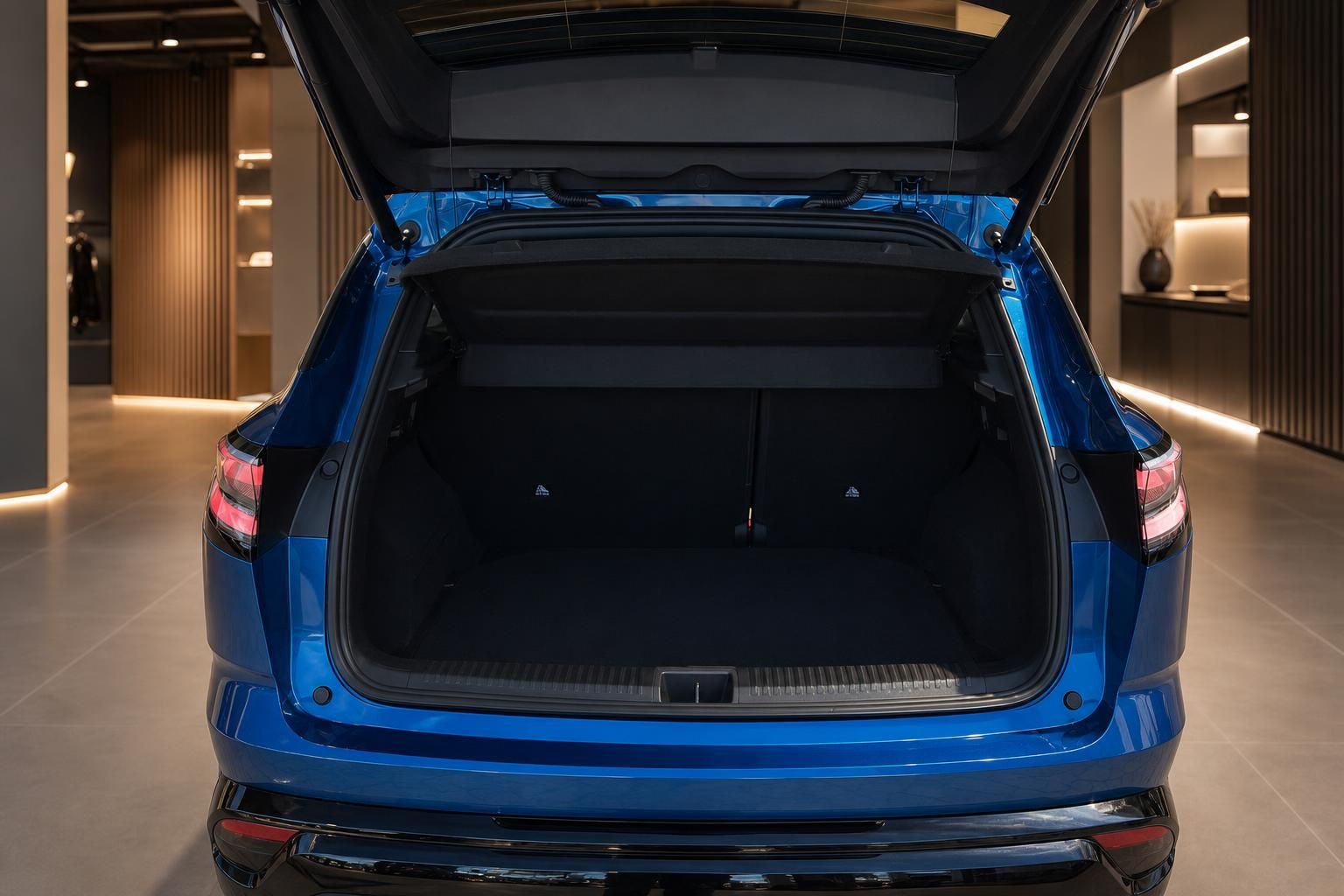 Blauer SUV mit geöffneter Heckklappe und geräumigem Kofferraum im Autohaus