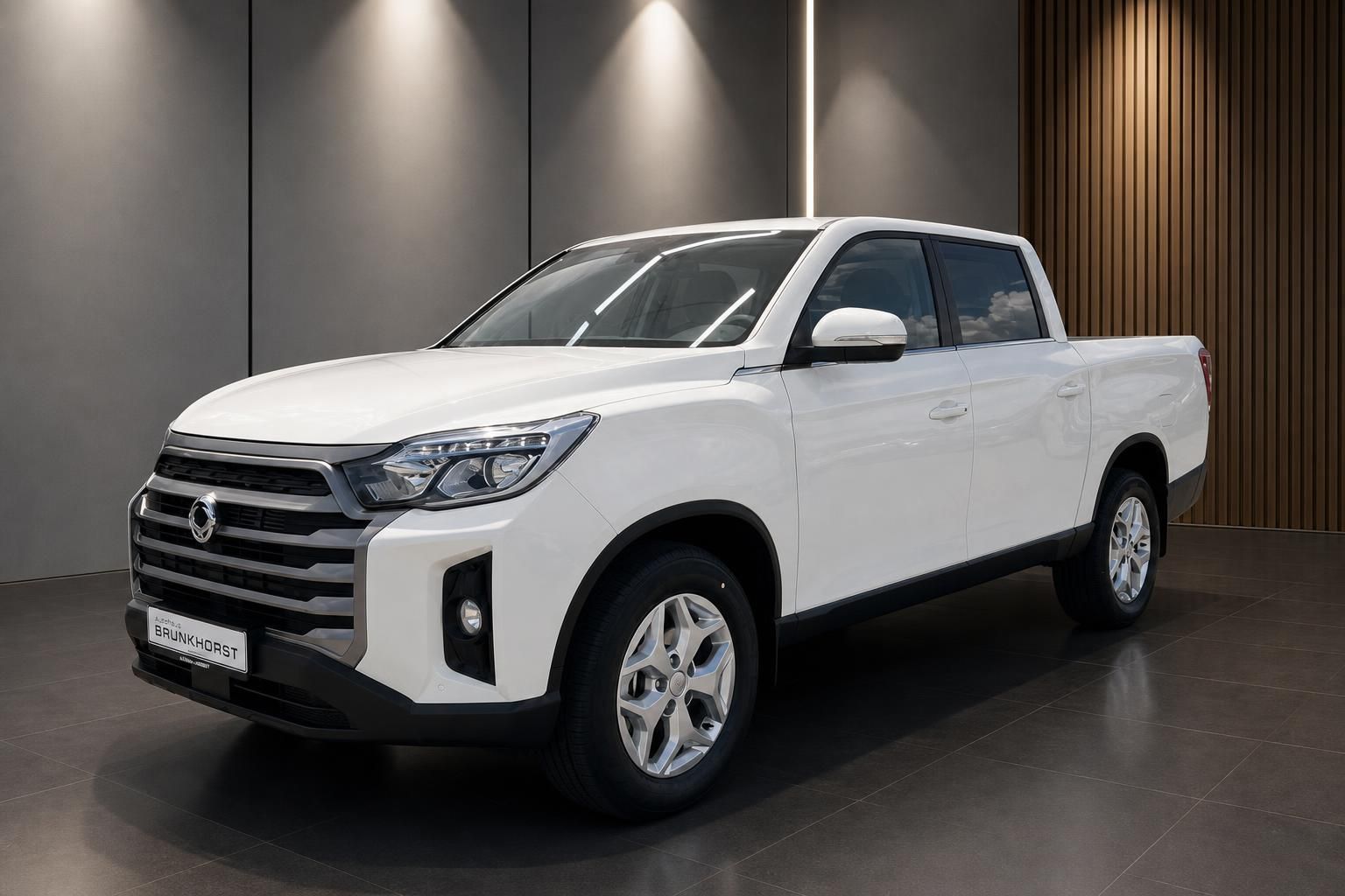 Weißer Pickup-Truck in modernem Showroom - Seitenansicht mit Alufelgen und eleganter Beleuchtung