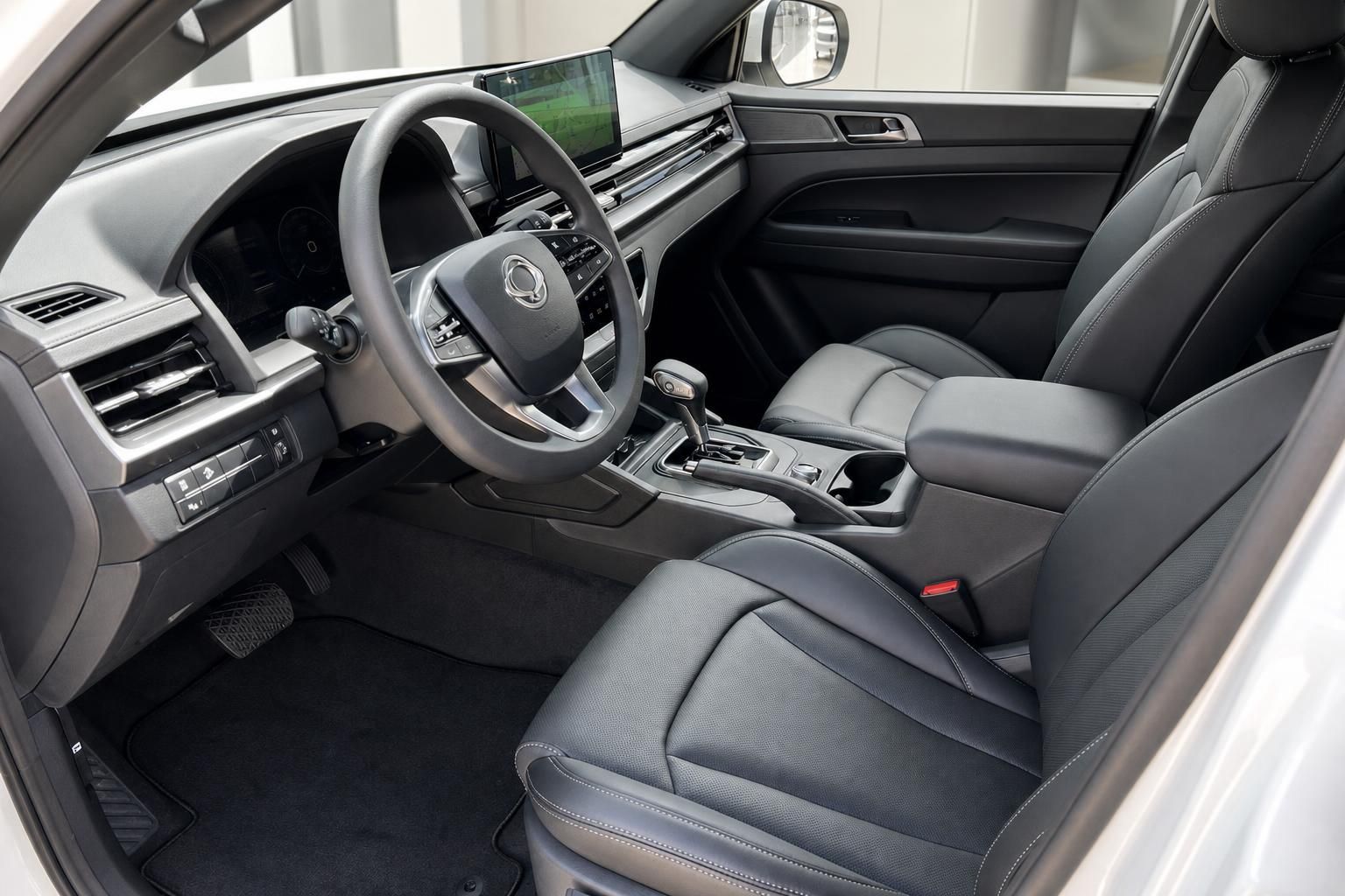 Fahrzeuginnenraum mit schwarzem Leder, Lenkrad, Mittelkonsole und modernem Infotainment-Display