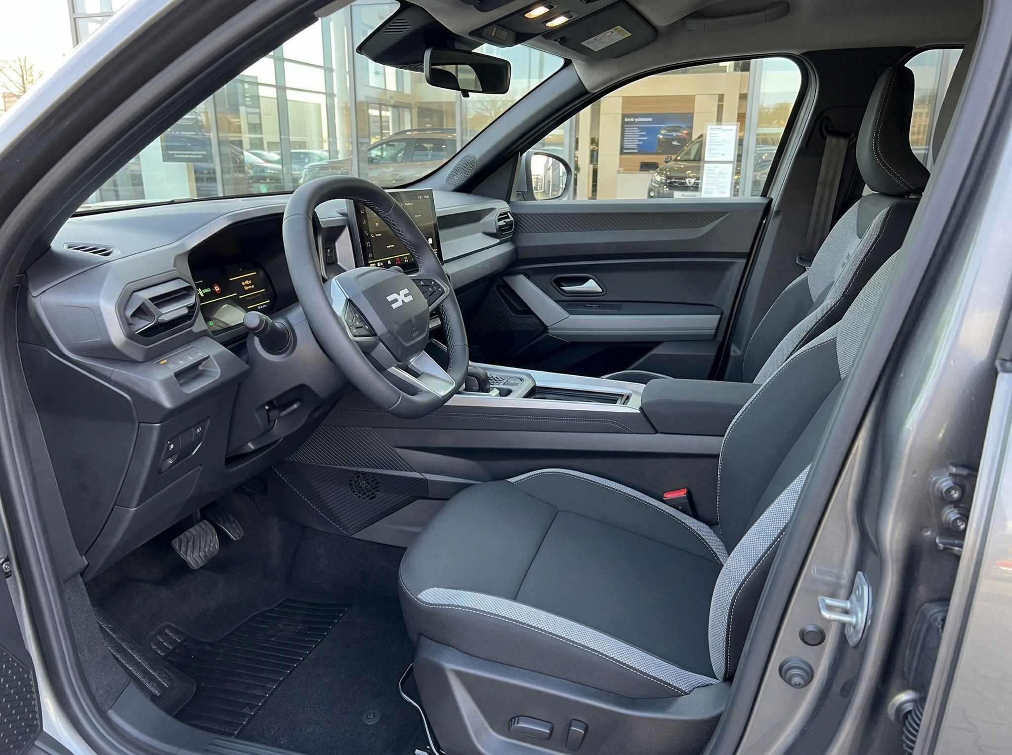 Dacia Innenraum schwarz-grau mit Lenkrad, Armaturenbrett und Fahrersitz