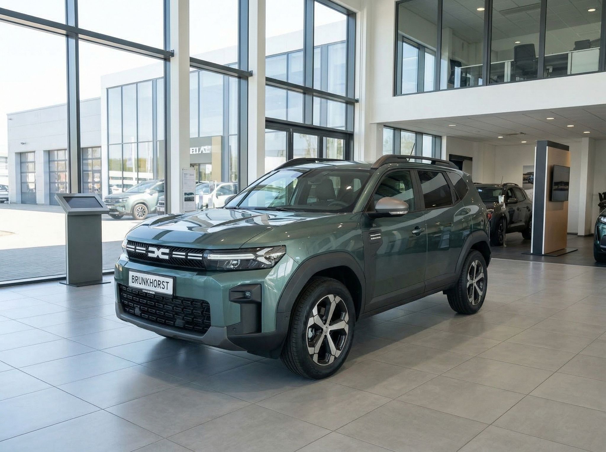 Dacia Bigster SUV in grün im Autohaus Showroom - Frontansicht mit Dachträger