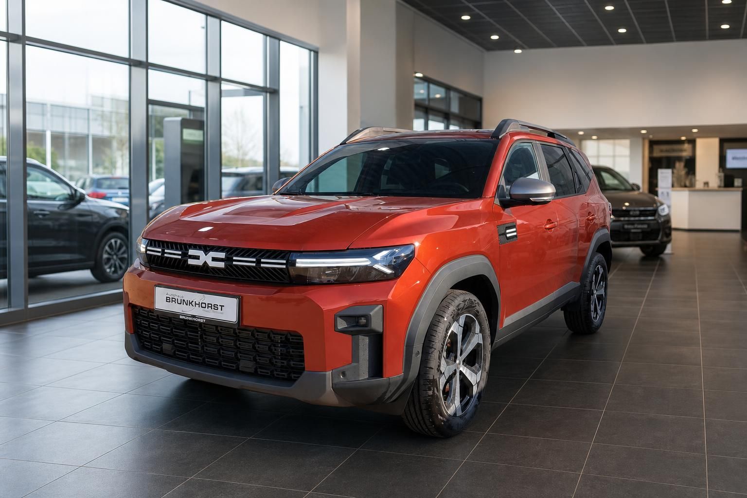 Dacia Bigster SUV orangerot Seitenansicht Autohaus Brunkhorst Showroom moderne Ausstattung