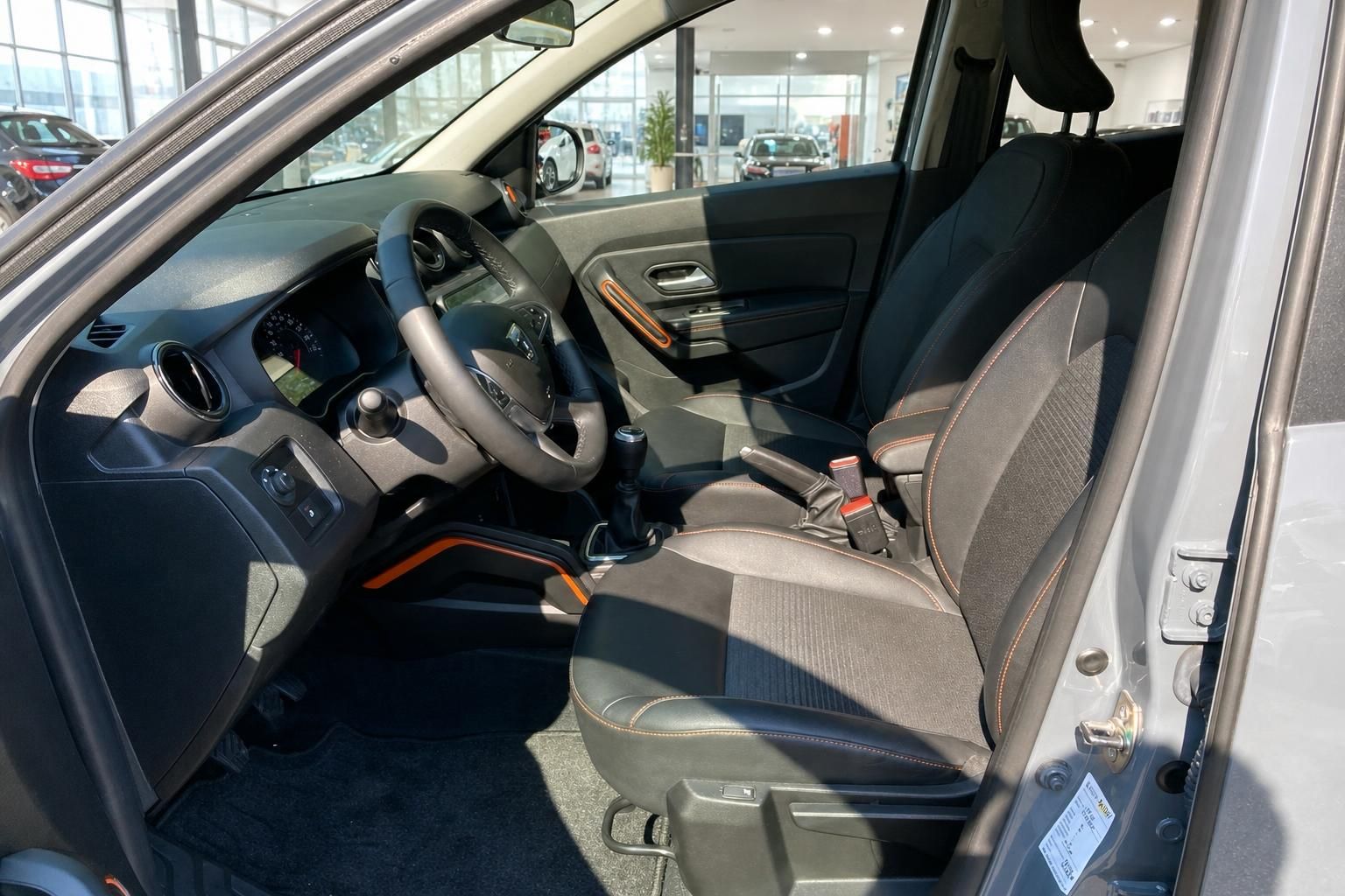 Dacia Duster Innenraum – Vordersitze mit orangefarbenen Ziernähten und Cockpit