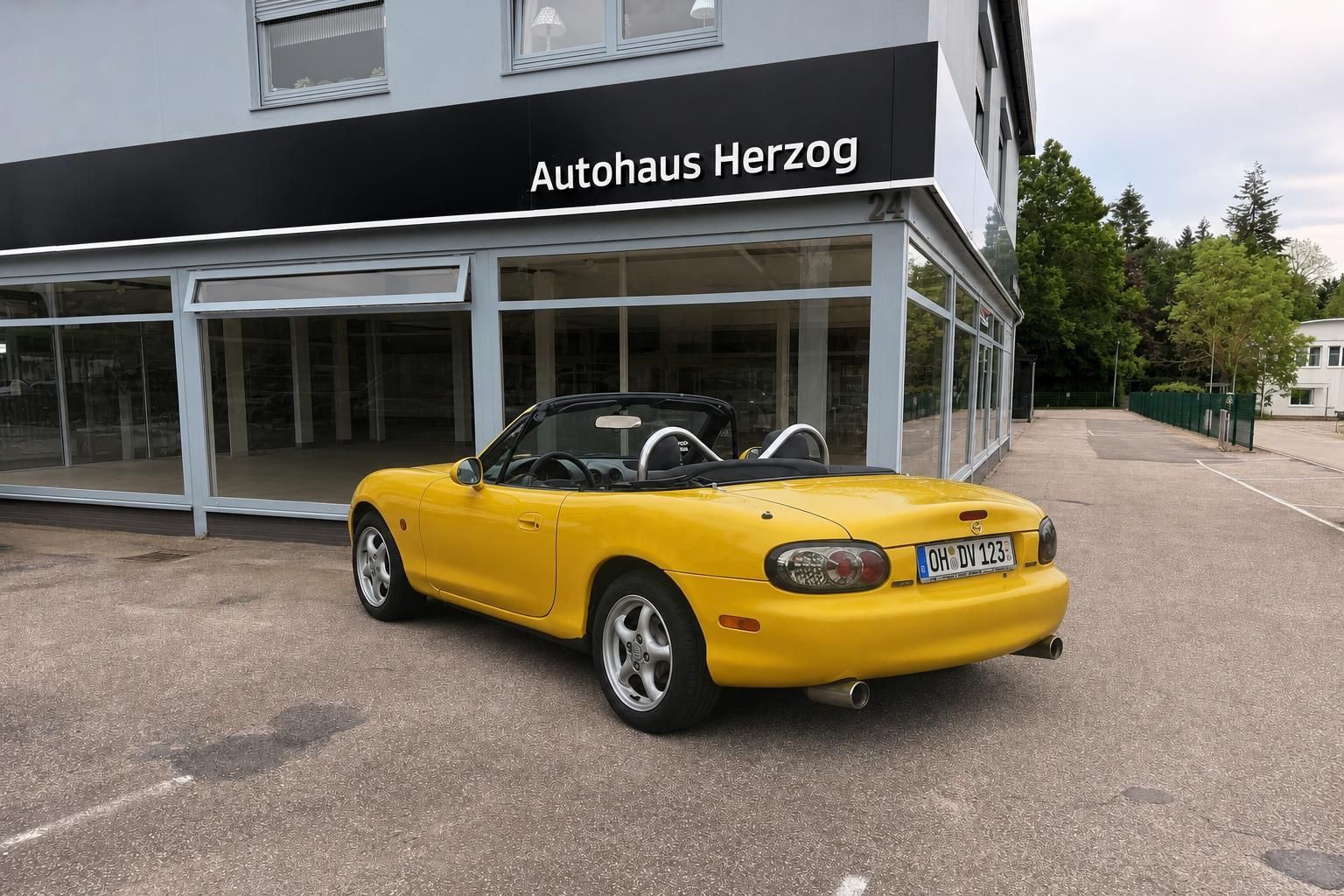 Gelber Mazda MX-5 Roadster Heckansicht mit deutschem Kennzeichen vor Autohaus