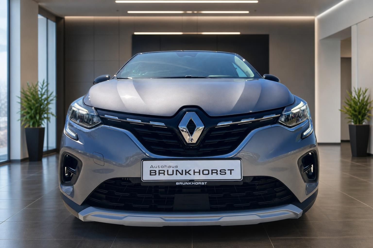 Renault Captur Frontansicht in grau - SUV von vorne im Autohaus-Showroom fotografiert