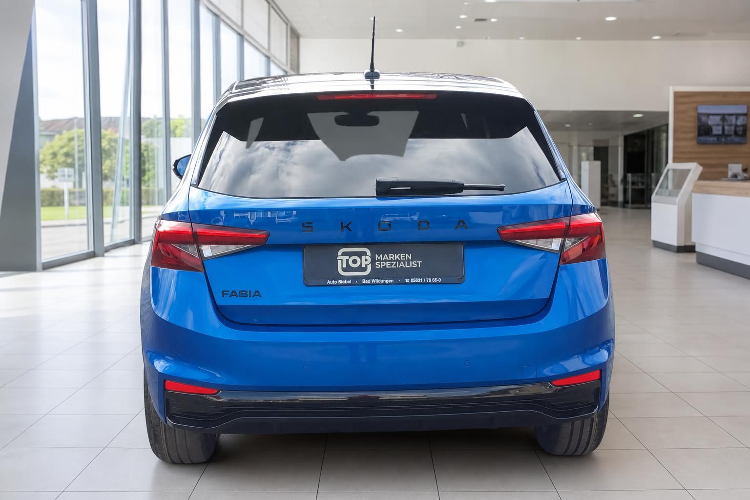 Blauer Skoda Fabia Heckansicht im Autohaus - kompakter Kleinwagen mit schwarzem Dach