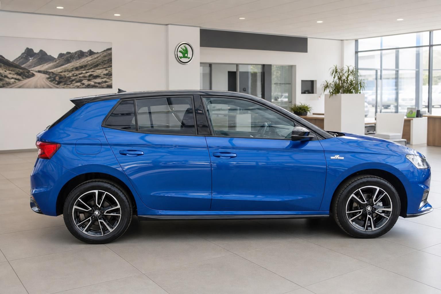 Blauer Kompaktwagen von der Seite im Autohaus - elegante Seitenansicht mit Alufelgen