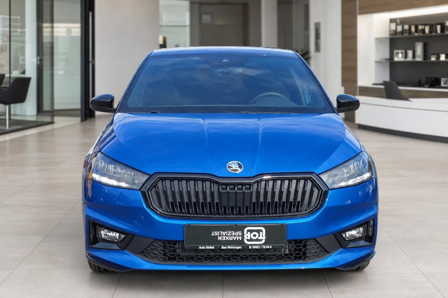 Frontansicht eines blauen Škoda im Autohaus - charakteristischer Kühlergrill und LED-Scheinwerfer
