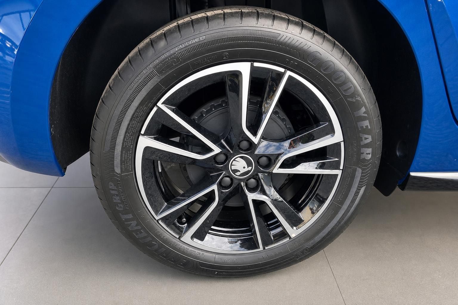 Nahaufnahme einer Alufelge mit Goodyear Reifen an blauem Fahrzeug - modernes Sportdesign