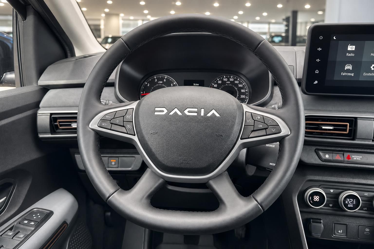 Dacia Lenkrad Nahaufnahme mit DACIA Logo, Tasten und Instrumentenanzeige im Hintergrund