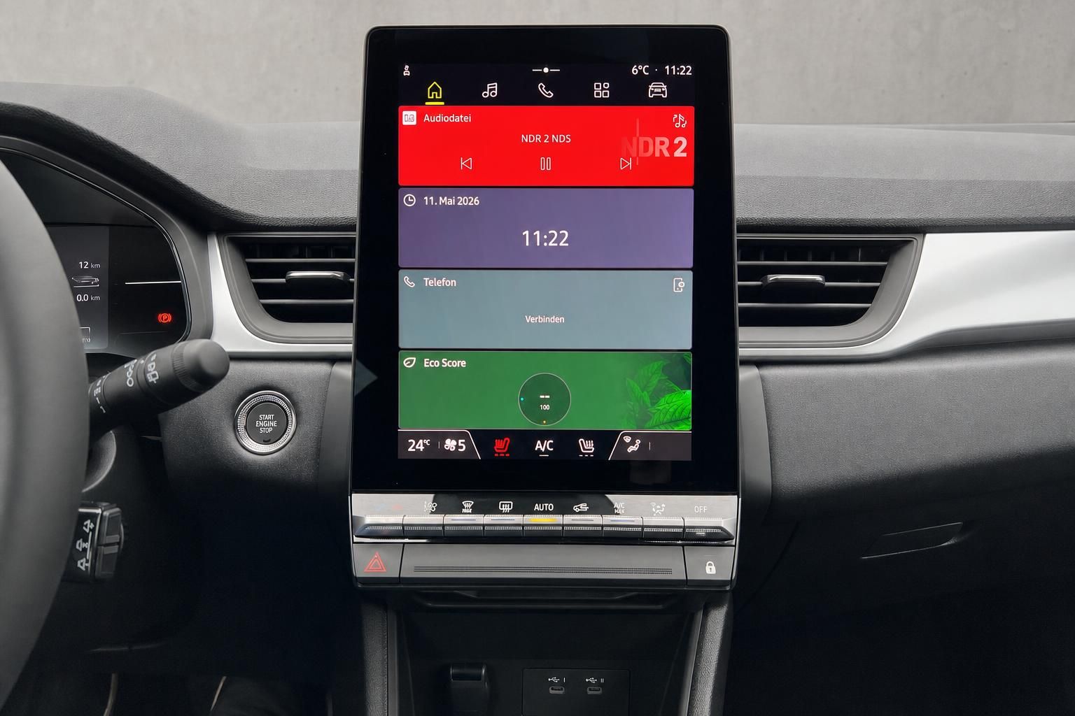 Zentraler Touchscreen im Fahrzeug zeigt Multimedia, Navigation und Klimasteuerung