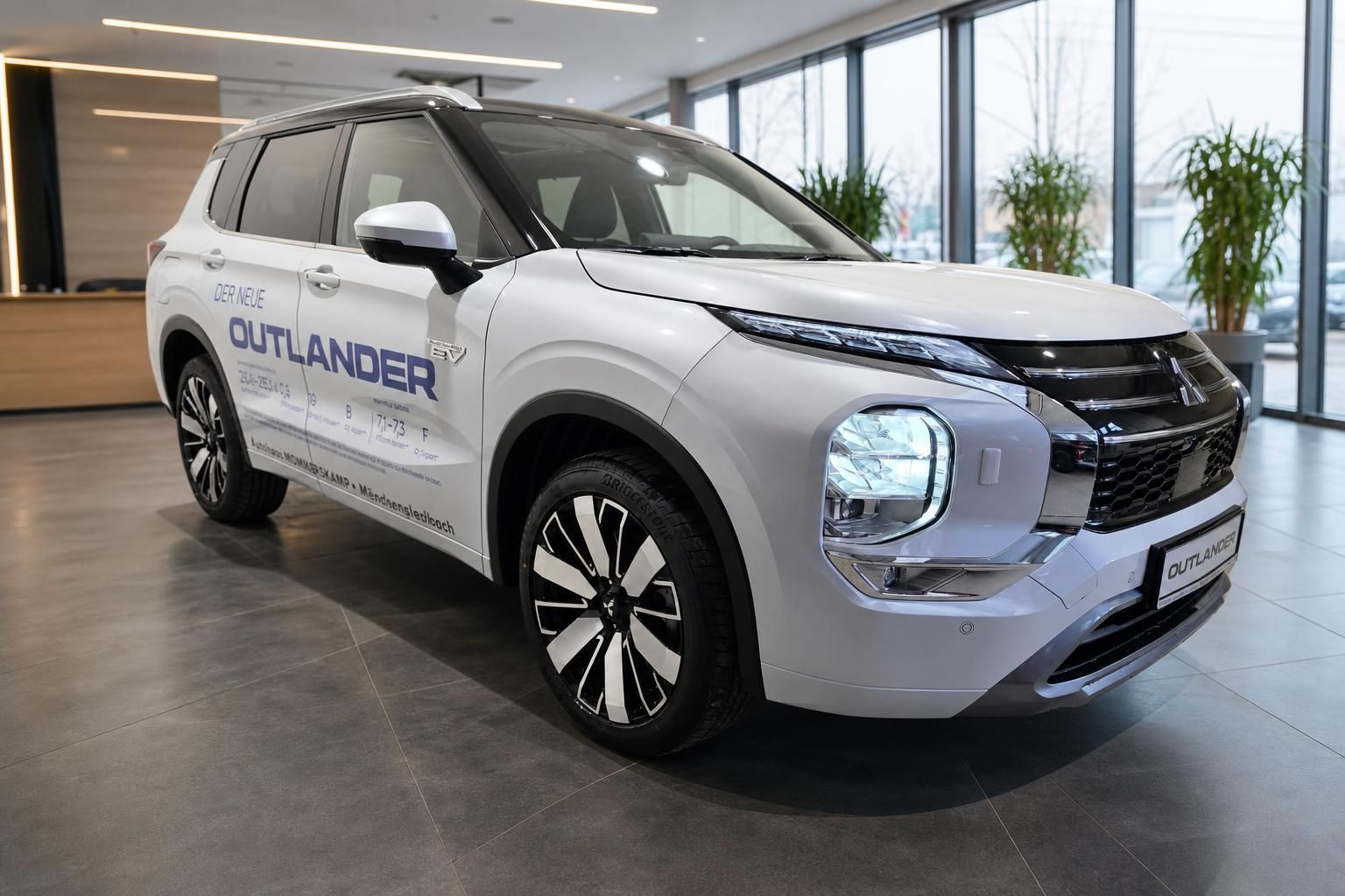 Mitsubishi Outlander PHEV in Weiss, seitliche Frontansicht im Autohaus