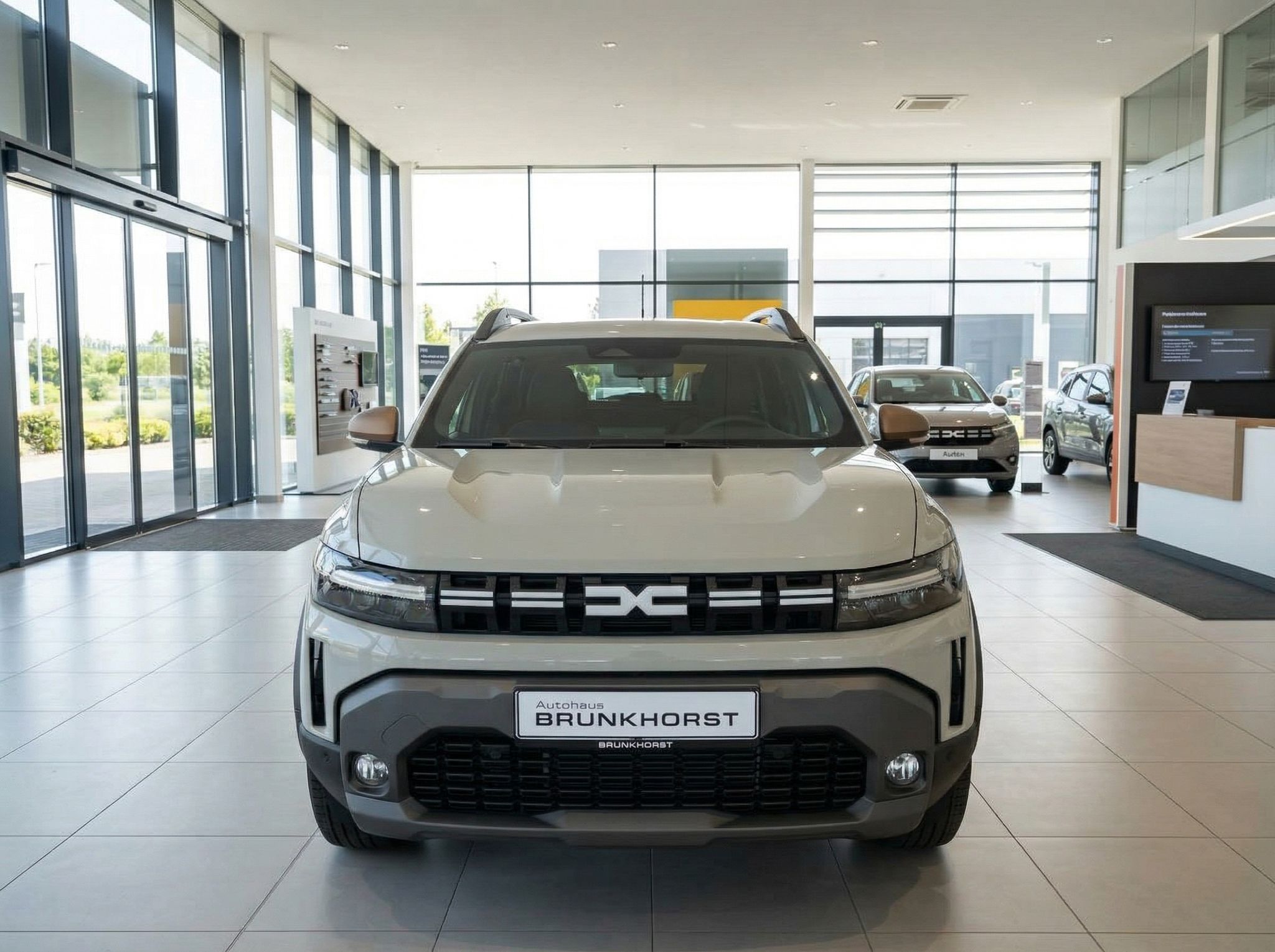 Weißer Dacia Duster SUV Frontansicht im modernen Autohaus mit Glasfassade und anderen Fahrzeugen