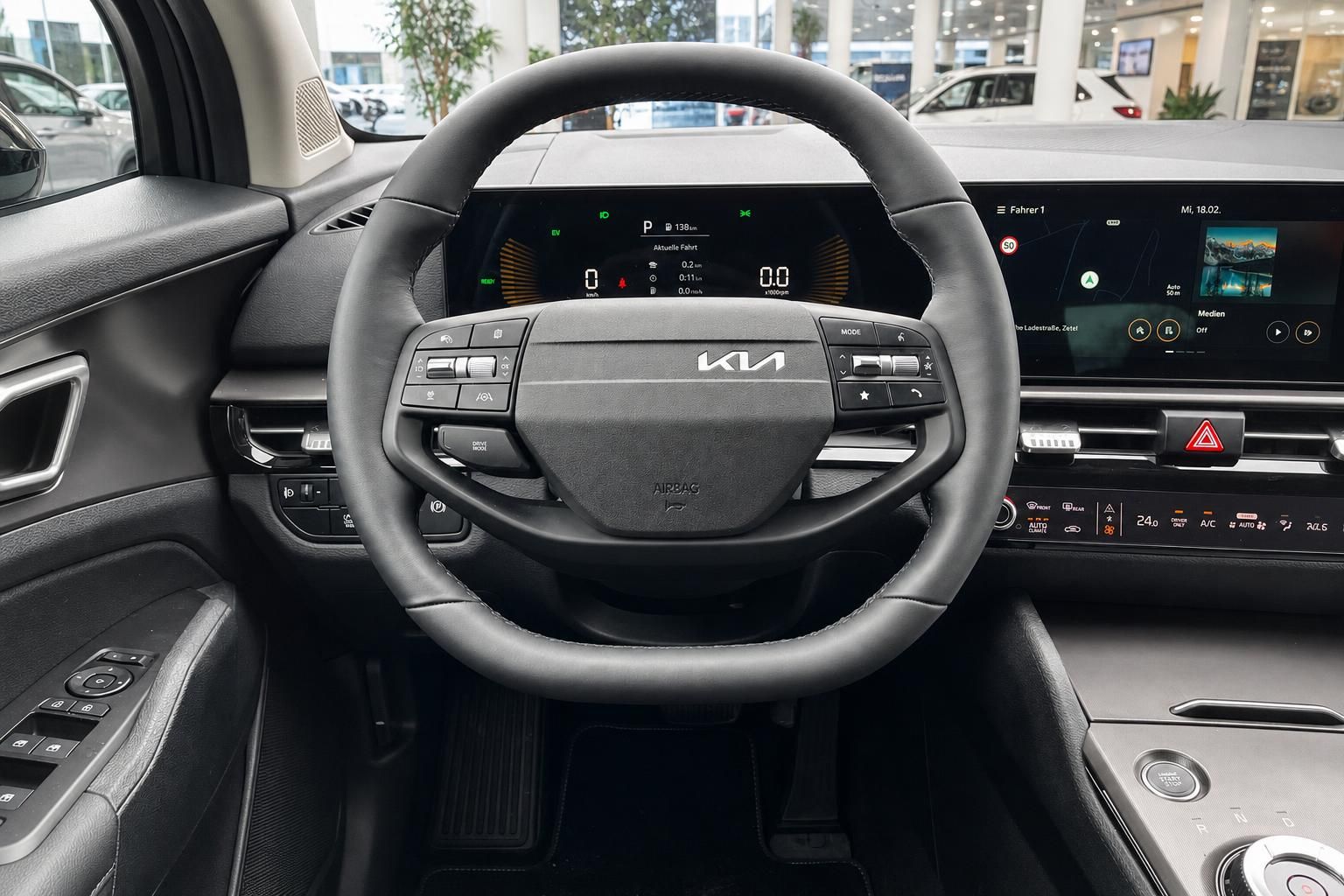 Kia Lenkrad mit Bedienelementen und digitalem Cockpit-Display im Innenraum