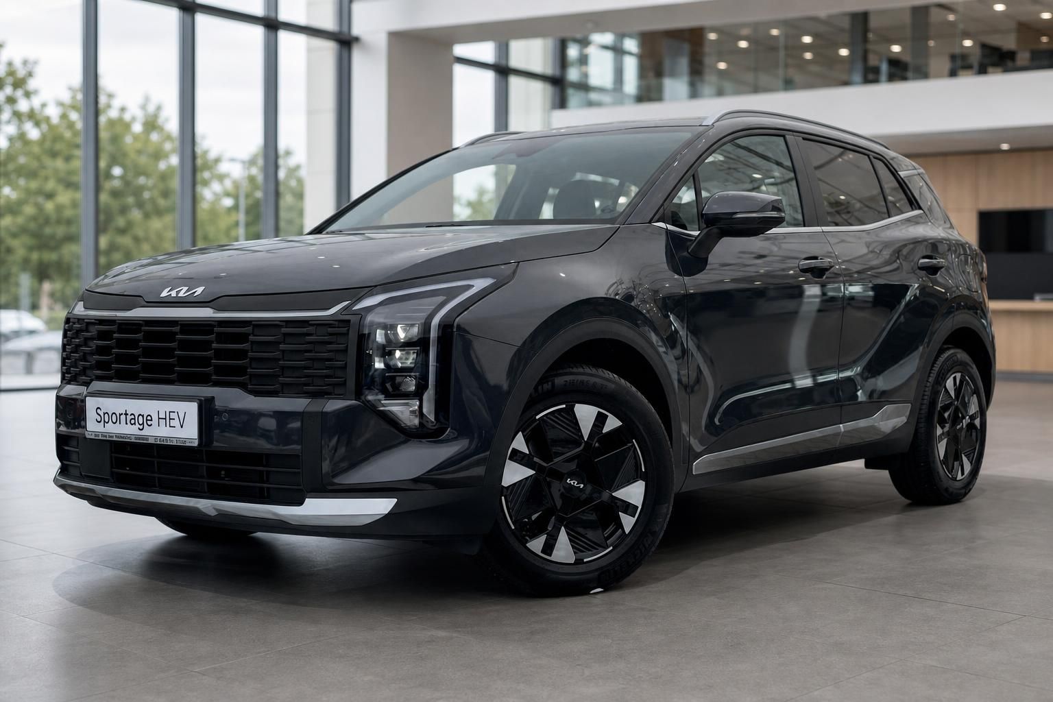 Kia Sportage HEV Frontansicht schraeg, dunkelgrau im Showroom