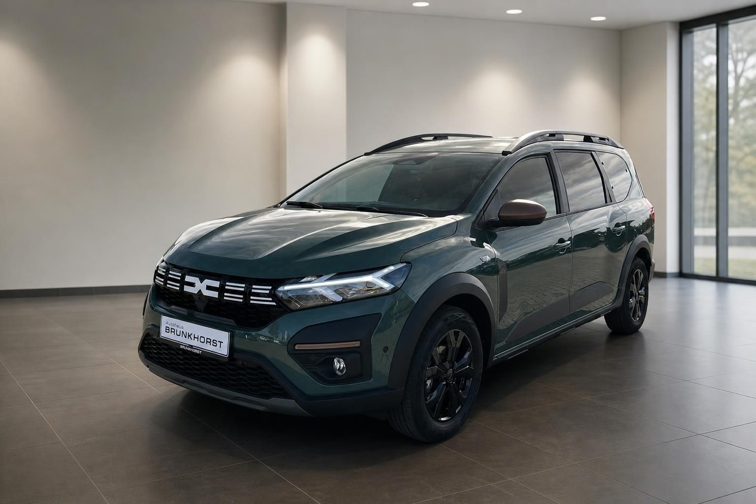 Dacia Familienauto grün metallic Schrägansicht vorne links im modernen Showroom