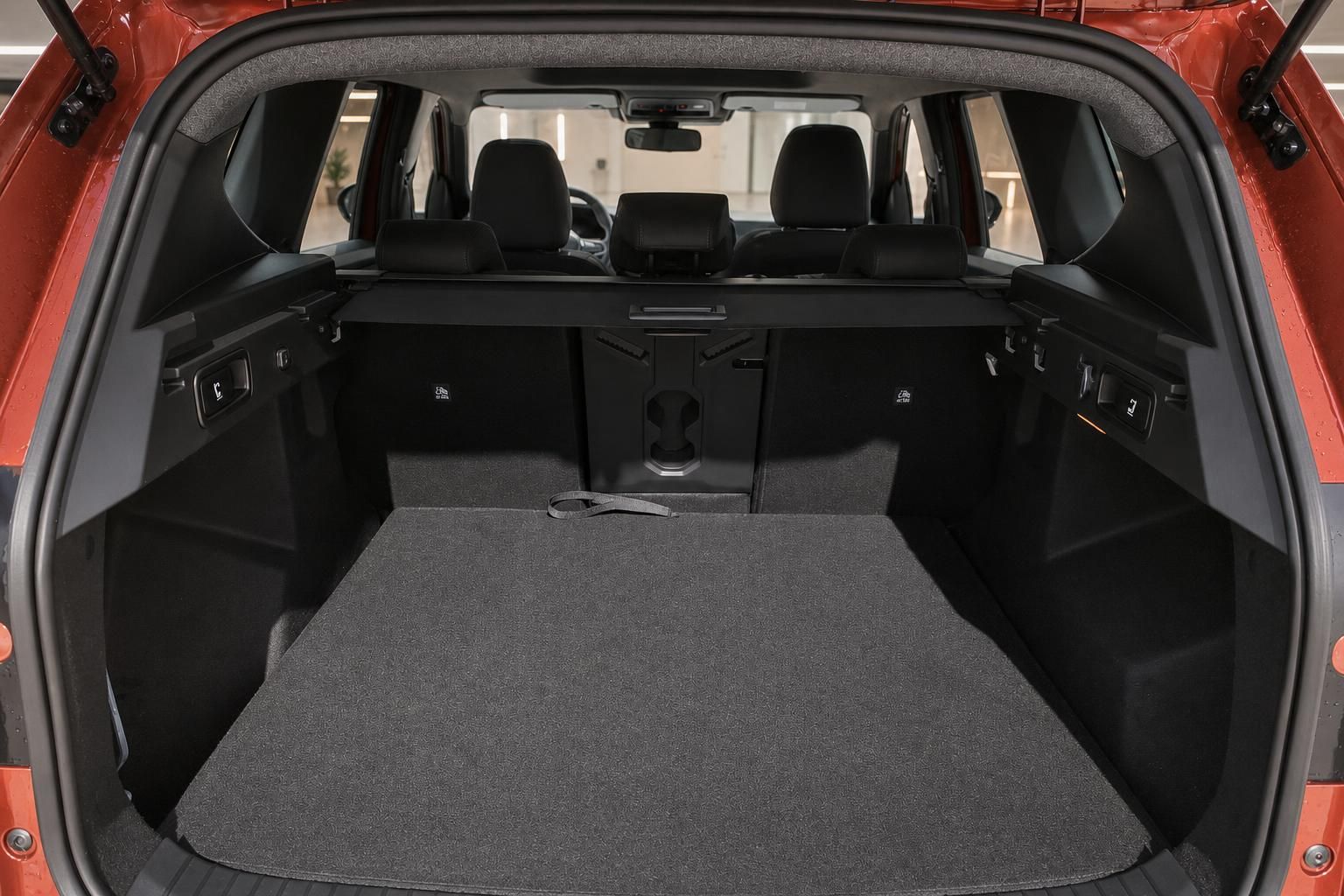 Kofferraum eines roten SUV mit umgeklappten Rücksitzen und viel Stauraum