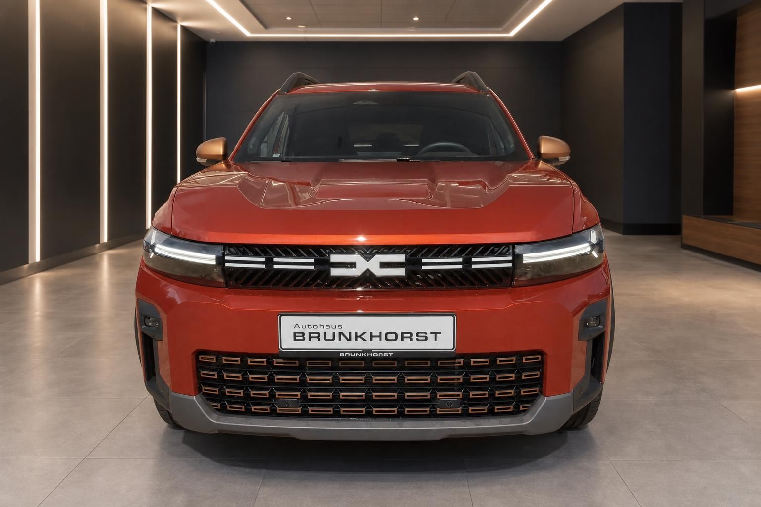 Dacia Bigster orange, direkte Frontansicht mit Kühlergrill und Scheinwerfern