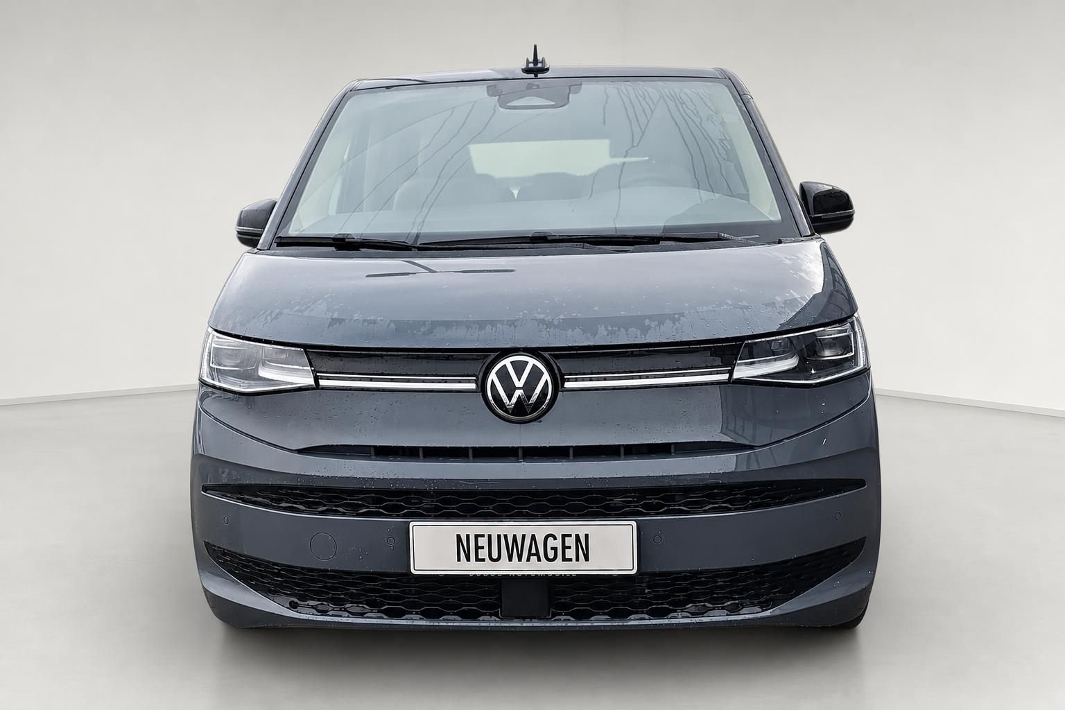 VW Multivan grau, Frontansicht mit VW Logo und Kuehlergrill