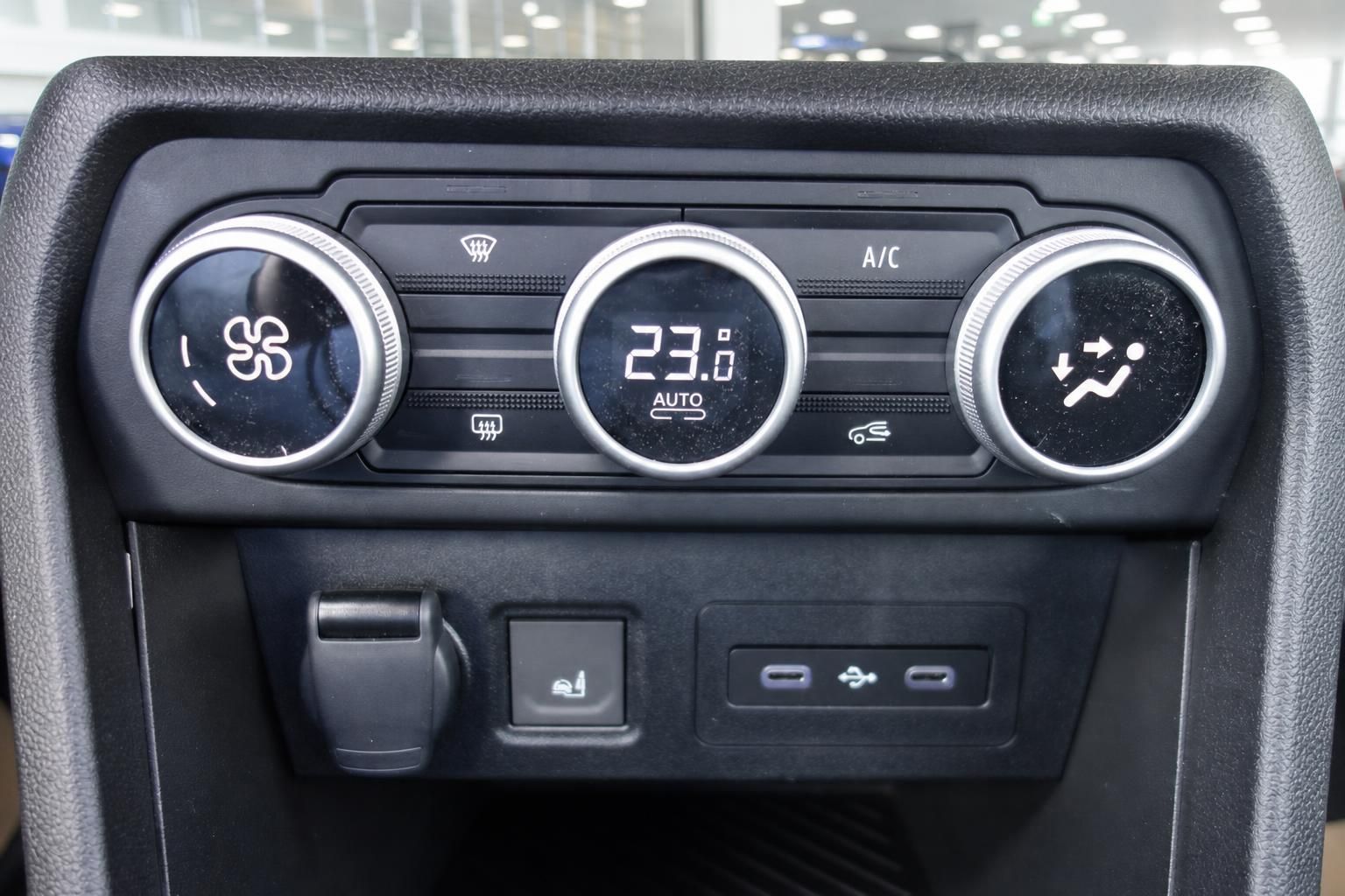 Klimaautomatik-Bedienfeld im Fahrzeug mit digitaler Temperaturanzeige und Lüftungsreglern