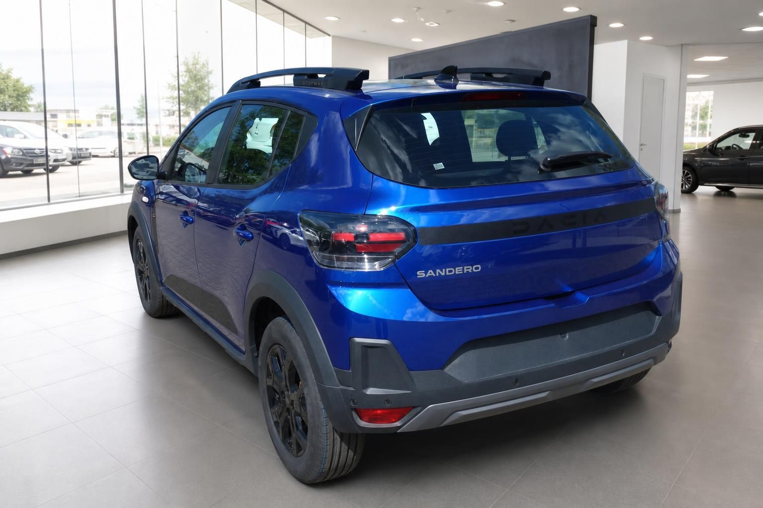 Blauer Dacia Sandero SUV Heckansicht mit Rücklichtern und Sandero Schriftzug im Autohaus