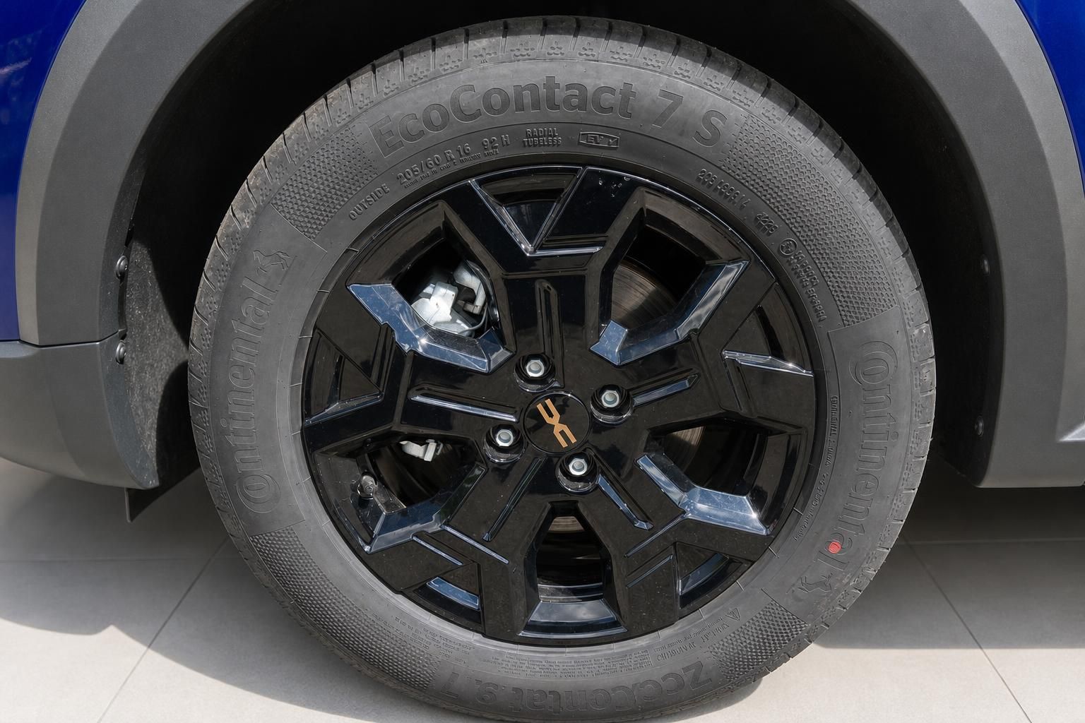 Schwarze Leichtmetallfelge mit Continental EcoContact 7 S Reifen am blauen Dacia Sandero SUV