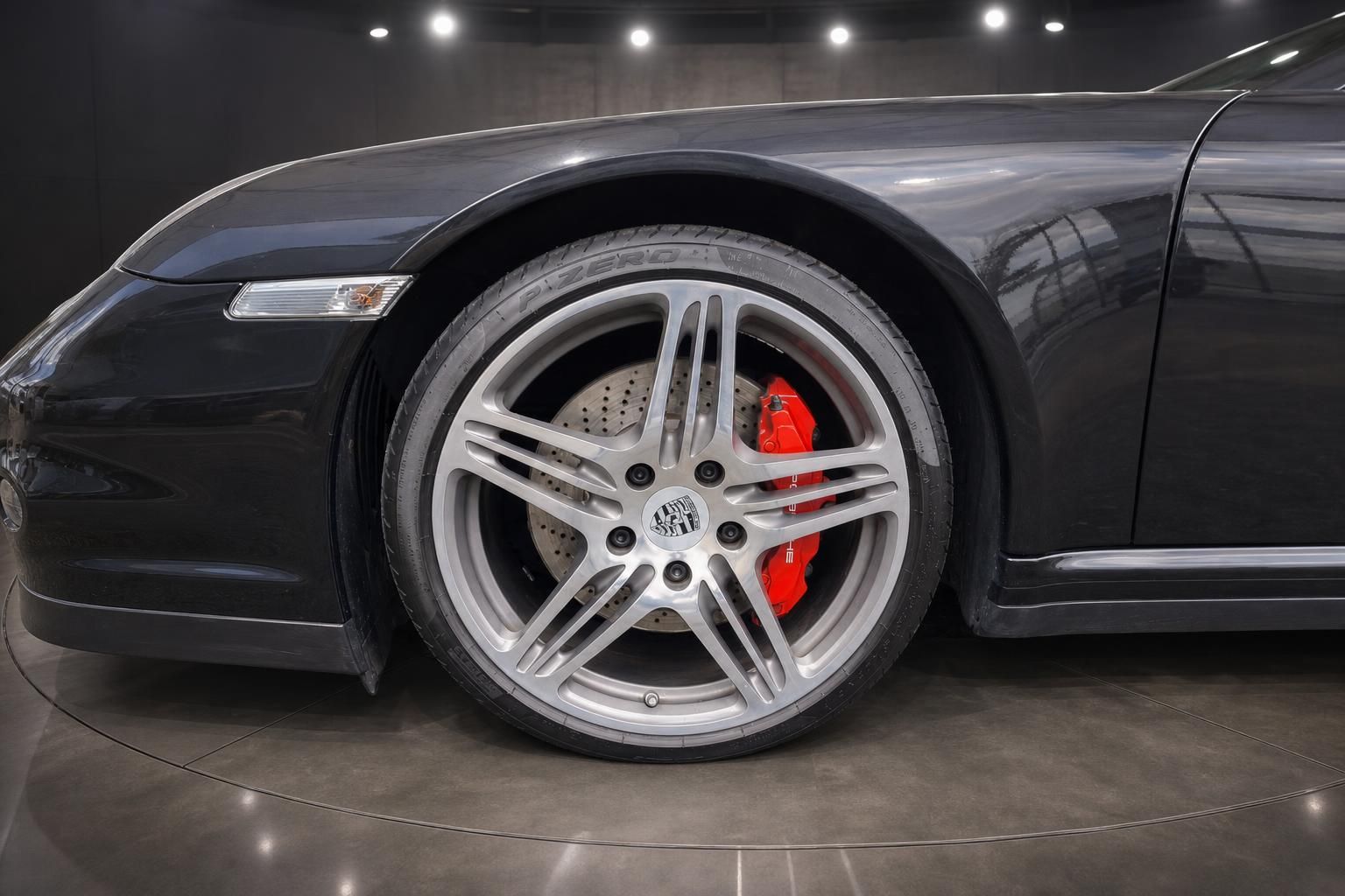 Porsche Sportfelge Detail mit rotem Bremssattel und Pirelli Reifen
