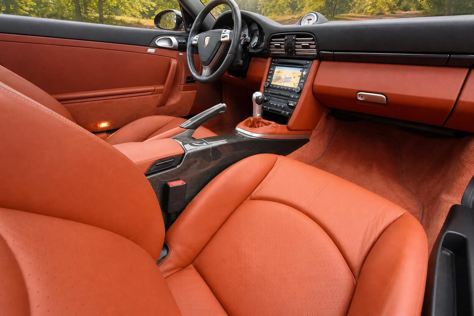 Porsche Cockpit mit orangenem Leder - Lenkrad, Mittelkonsole und Navigationssystem