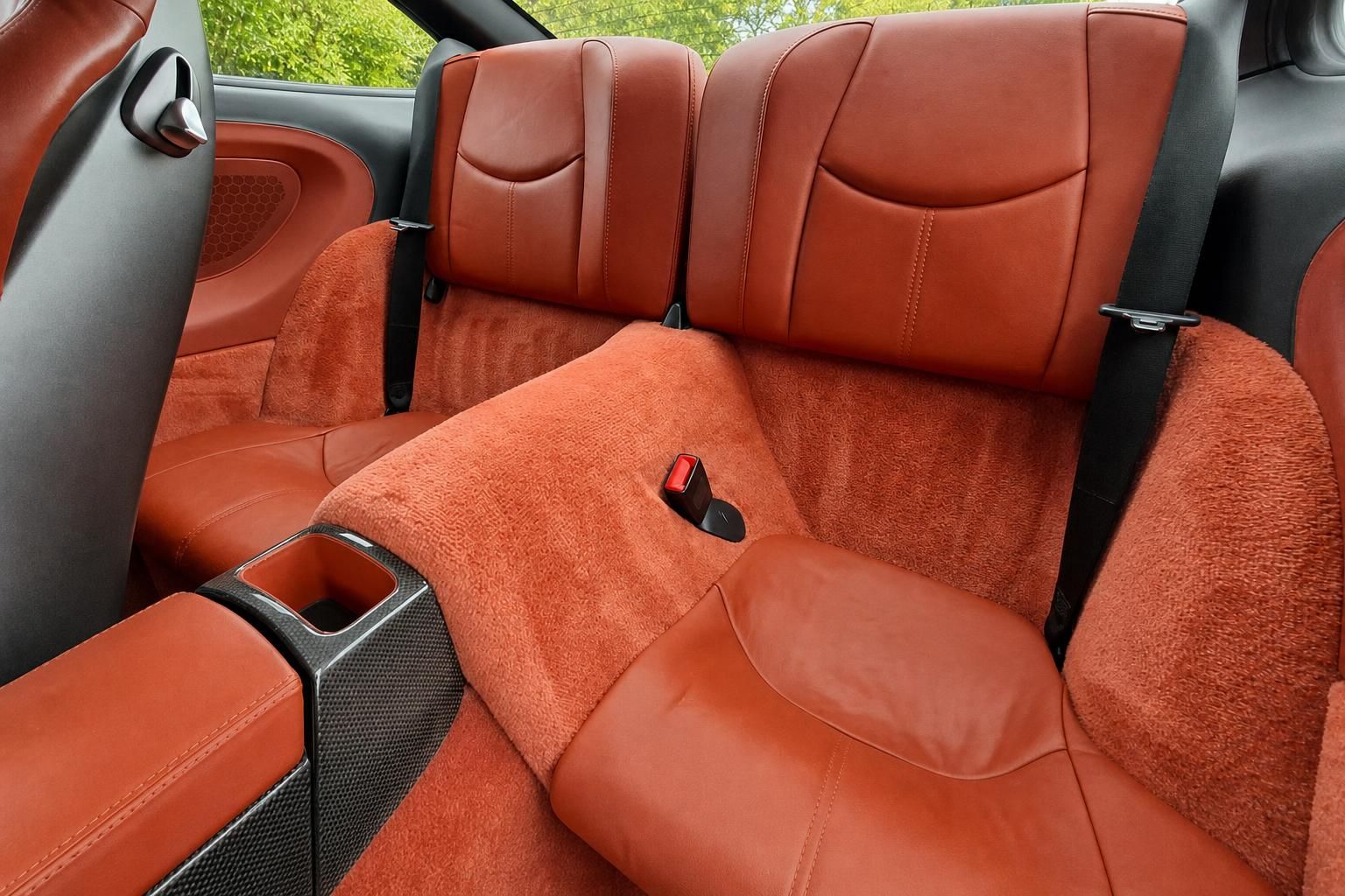 Porsche Rücksitze in orangefarbenem Leder mit Carbon-Mittelkonsole