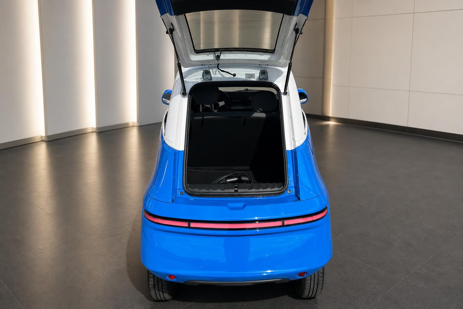 Blaues Elektrofahrzeug mit geöffnetem Kofferraum zeigt Laderaum und Heckklappe von oben