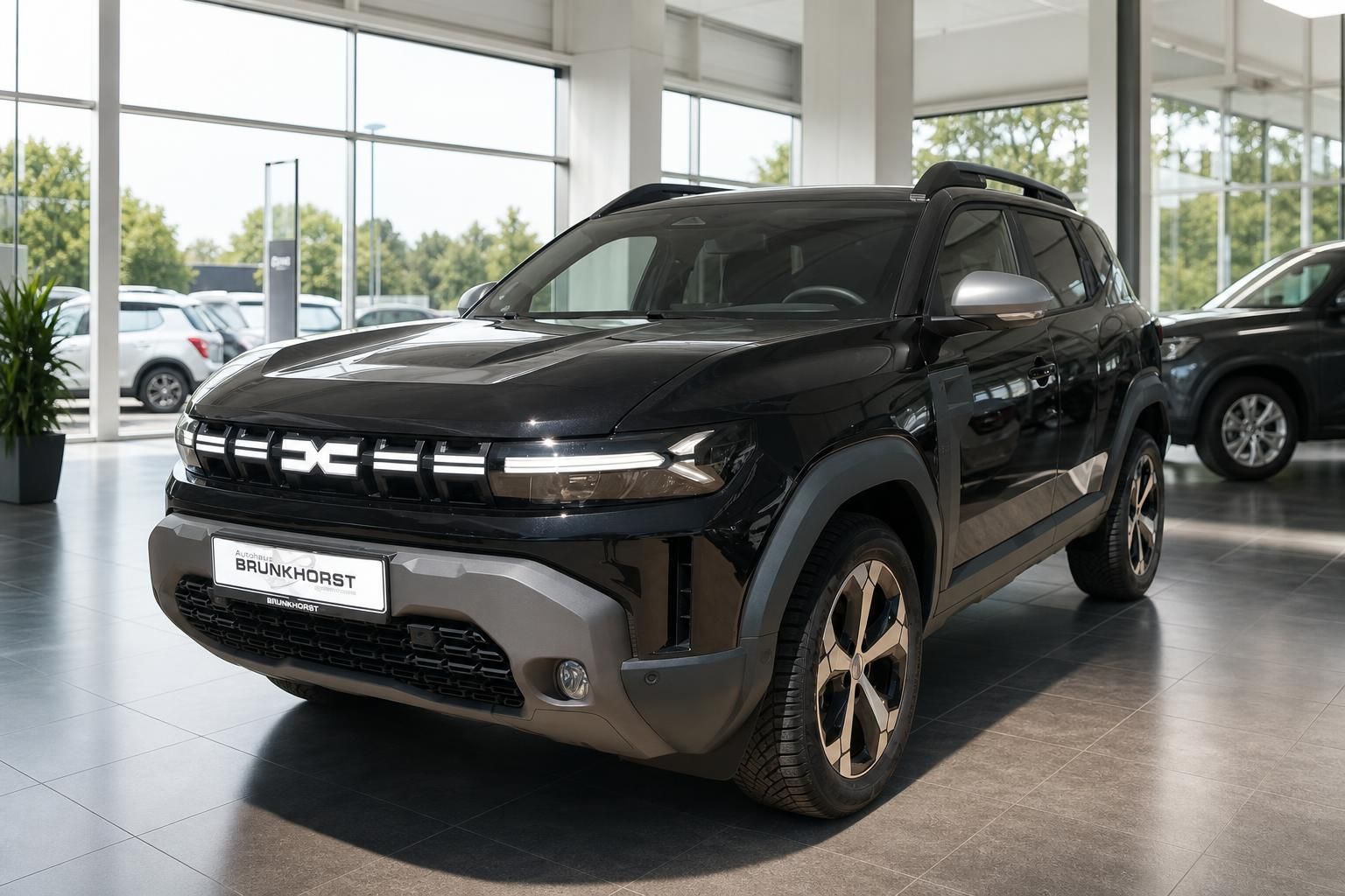 Schwarzer Dacia SUV im Autohaus Showroom - Dreiviertelansicht von vorne mit markanten Scheinwerfern