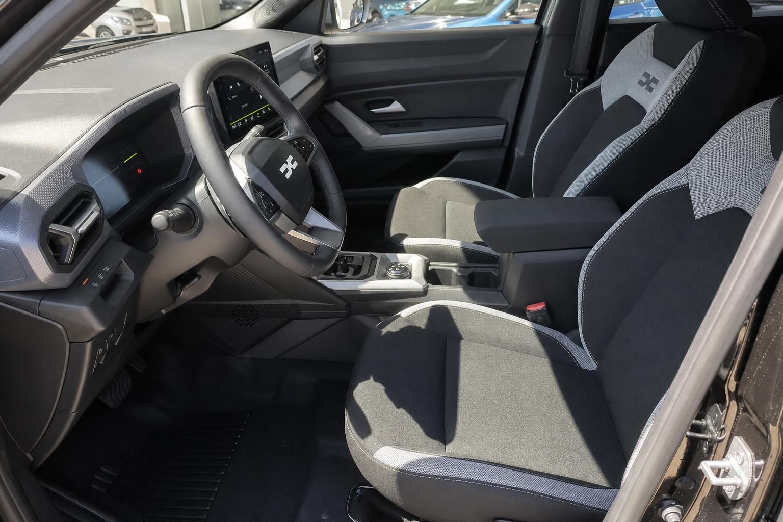 Dacia Fahrzeuginnenraum mit grauen Sportsitzen und schwarzem Interieur - Seitenansicht