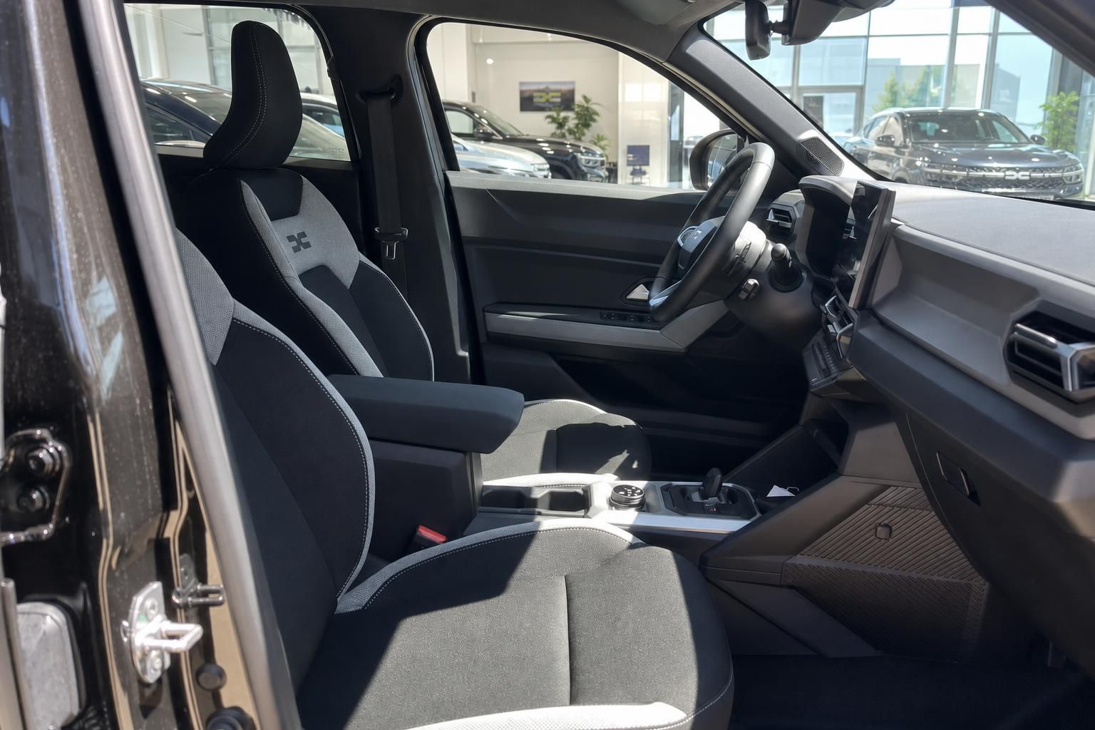 Auto Innenraum mit schwarz-grauen Sitzen und Lenkrad im Autohaus