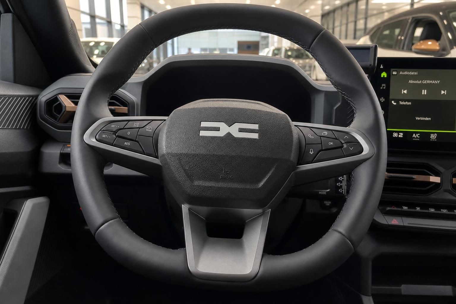 Dacia Innenraum - Lenkrad mit DC Logo und moderne Bedienelemente in schwarzer Ausstattung