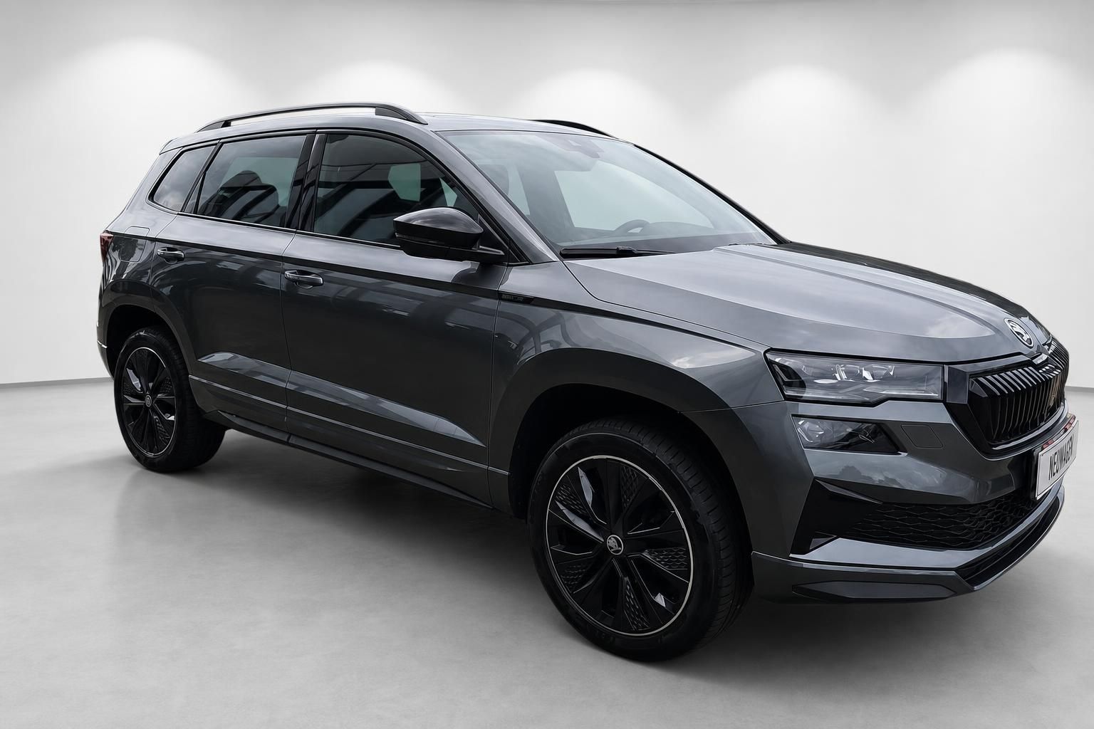 Skoda Karoq SUV Grau, Frontansicht schraeg mit schwarzen Felgen